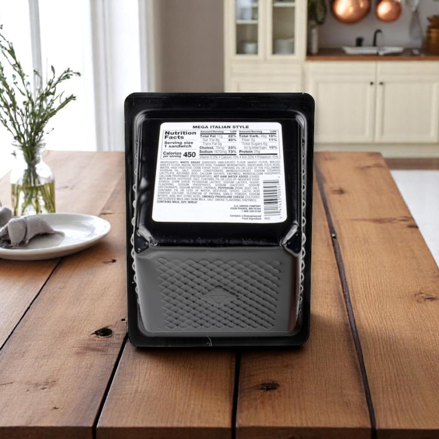 An E.A. Sween Market Mega Italian Style Sandwich Wedge–6 oz, individually wrapped with nutrition label visible, sits on a wooden table in a kitchen, ready for a grab-and-go meal with deli-quality taste.