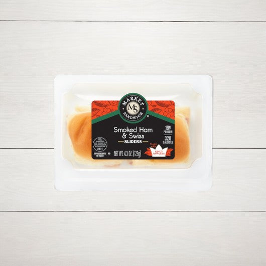 An E.A. Sween package of Smoked Ham and Swiss Sliders, with a 30-day cooler shelf life once thawed, rests on a white wooden surface.