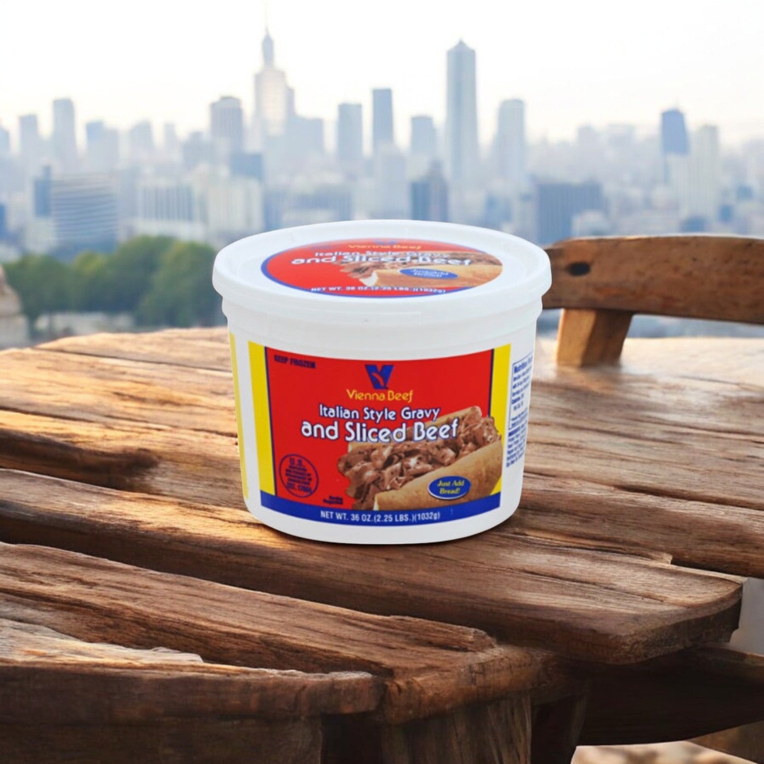 An Easy Lunches Chicago Classics Combo of Vienna Beef Hot Dogs and Italian-Style Beef with Gravy rests on a wooden table with a city skyline backdrop, embodying the spirit of Chicago.