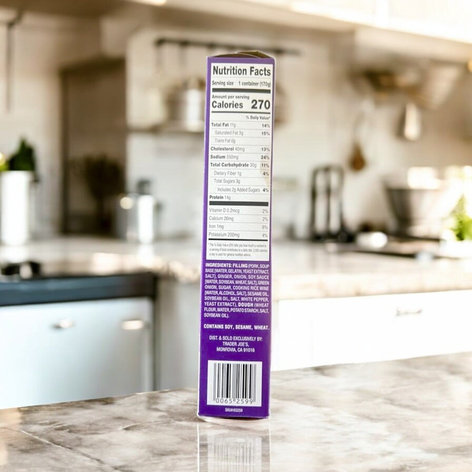 A box of Steamed Pork & Ginger Soup Dumplings from Easy Lunches sits on the kitchen counter, its packaging reminiscent of the meticulous detail found in traditional Asian flavors.