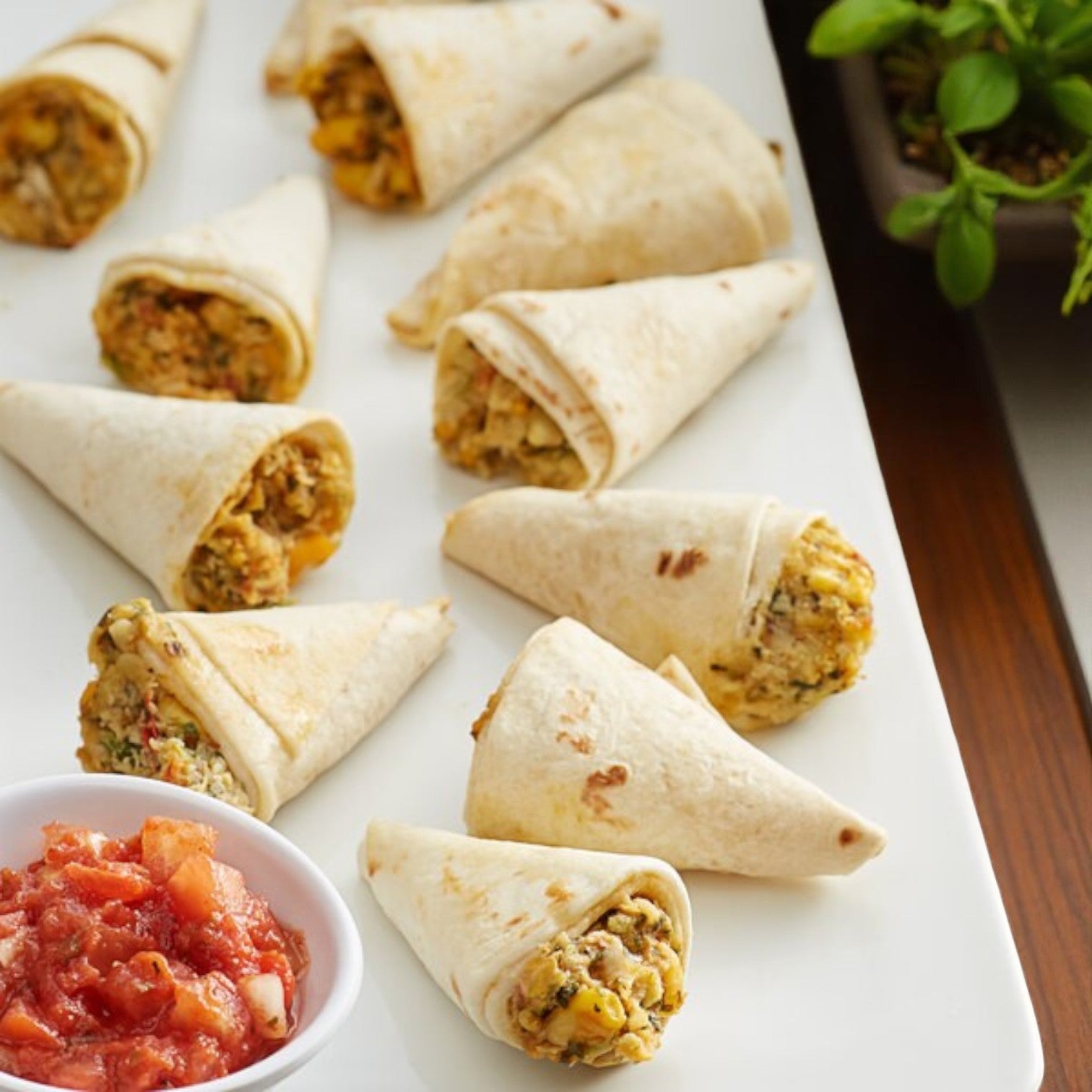 A white platter with Sysco Reliance™ Mozzarella Cheese Sticks (battered) served next to a small bowl of chunky salsa—a tasty, premium appetizer perfect for any occasion.