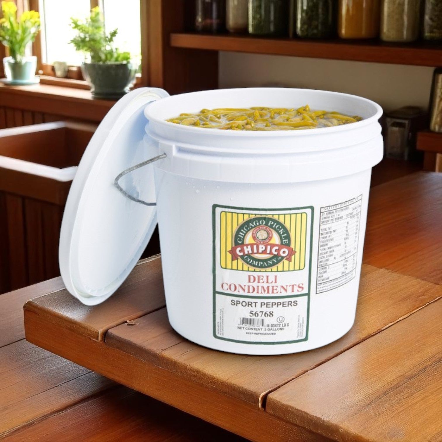 A 1/2 gallon jar of Vienna Beef Chipico Mild Sport Peppers sits open on a wooden counter, showing sliced Chicago-style peppers soaking in brine.