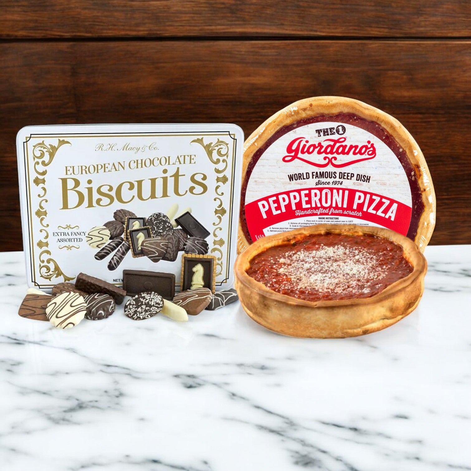 On the marble surface lies a luxurious R.H. Macy Co. and Giordano's 2 Pack Combo by Macy's, featuring a box of exquisite European chocolate biscuits alongside a packaged Giordano's pepperoni deep dish pizza for an indulgent blend of savory and sweet delights.