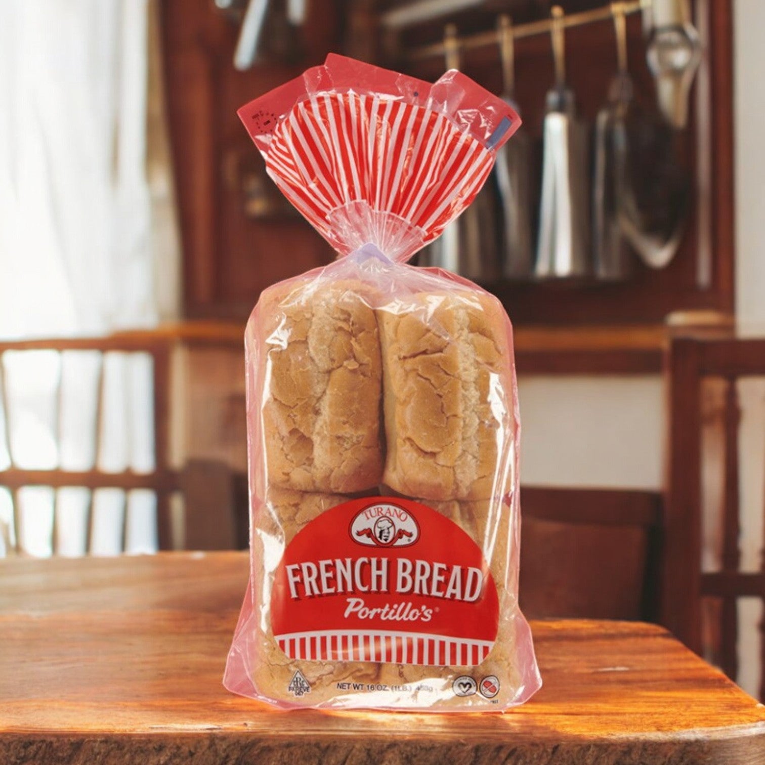 A package of Portillo's French Bread – 16 oz, 8 Pieces 🥖, with a crispy crust rests on a wooden kitchen table.