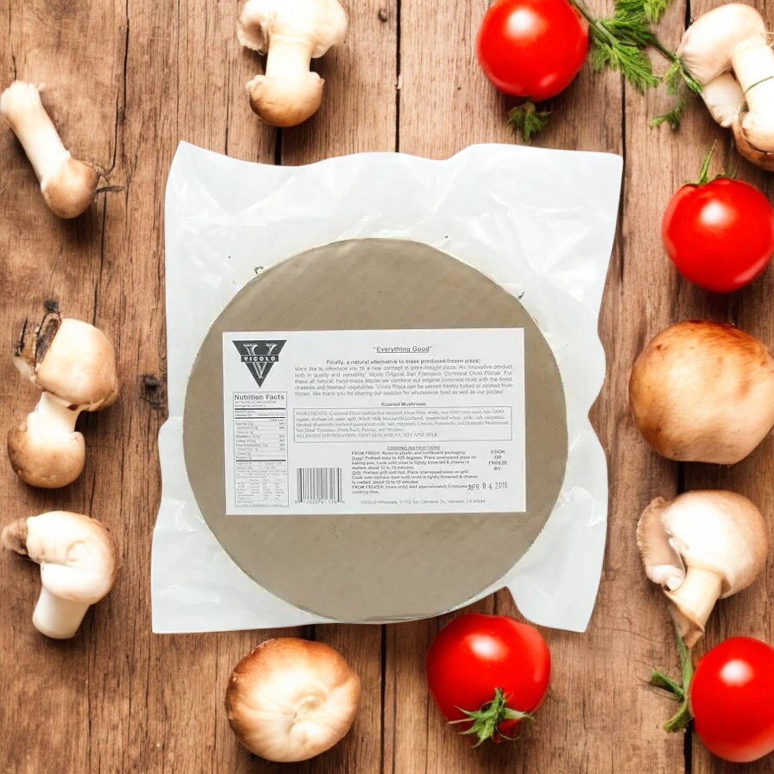 A vacuum-sealed Vicolo Roasted Mushroom Pizza sits on a wooden surface, surrounded by fresh mushrooms and tomatoes—perfect for a delicious meal.