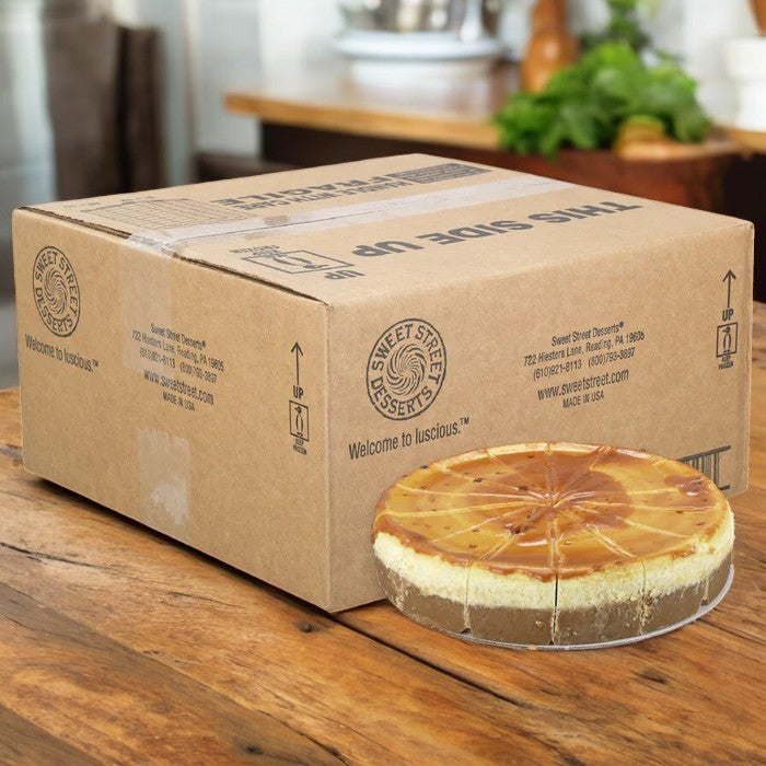 A Sweet Street Cheesecake Crème Brûlée with a caramelized sugar crust is partially outside its "This Side Up" box, labeled "Sweet Street Desserts," suggesting decadent individual servings.