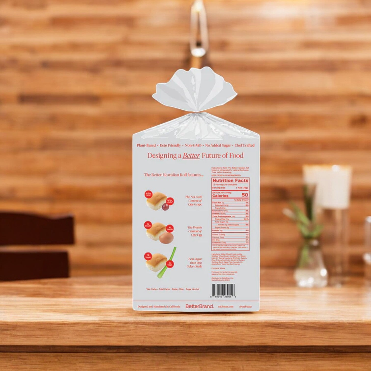 A bag of BetterBrand Hawaiian Rolls – Soft, Sweet & Perfectly Fluffy! (4 rolls per pack) sits on a wooden kitchen counter, white packaging facing back to display nutrition facts and product info. In stock and ready to ship!.