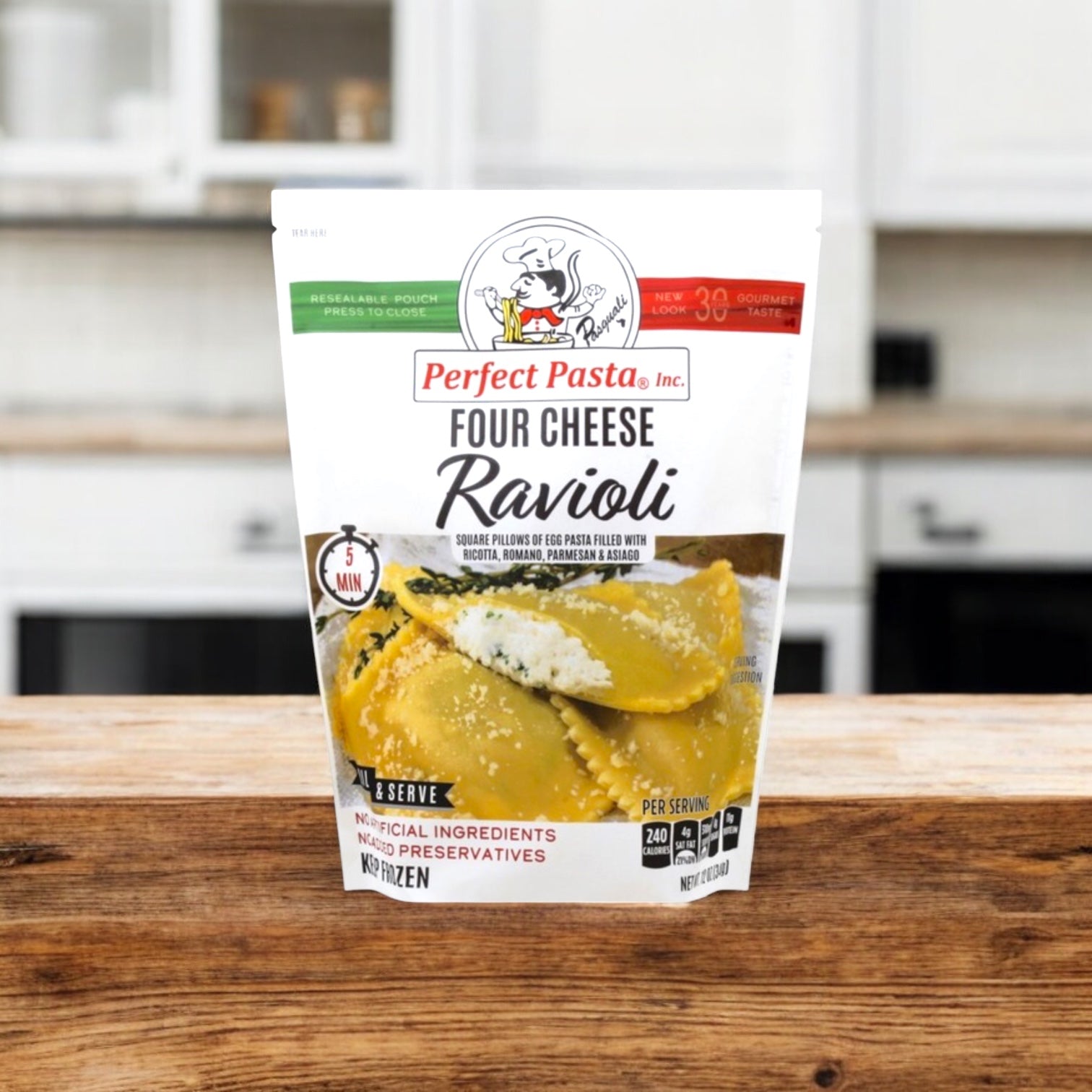 A pack of Perfect Pasta Four Cheese Ravioli, from Perfect Pasta, is shown on a wooden countertop in a modern kitchen.
