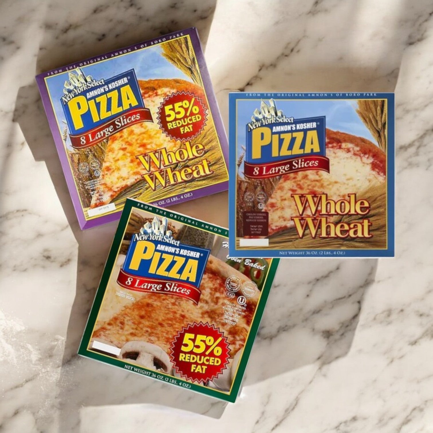 A 3-pack of Amnon's Kosher Pizza, featuring premium mozzarella cheese and 55% reduced fat, rests on a marble surface. Each ready-to-bake box contains 8 large whole wheat slices.