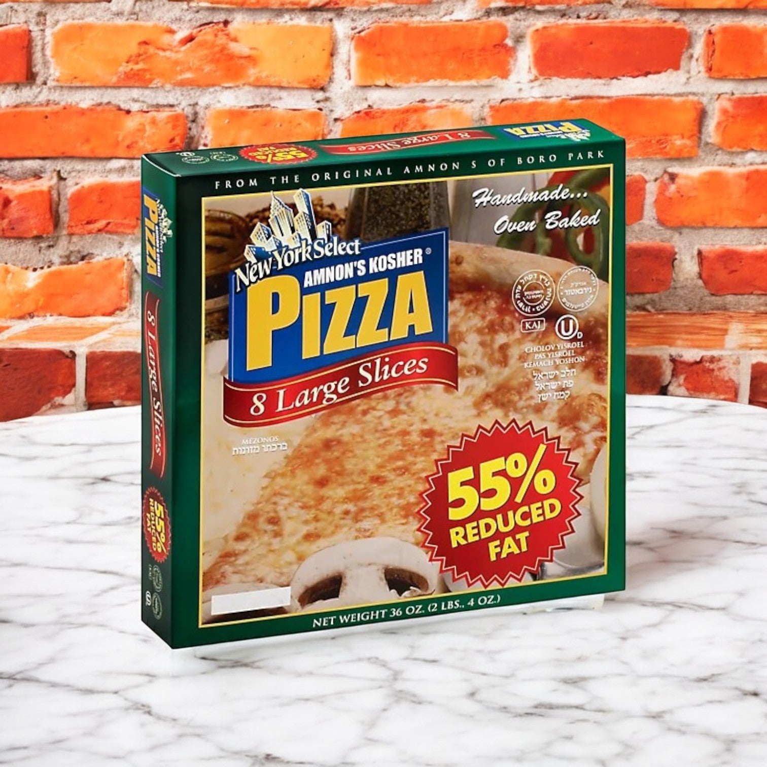 A 3-pack bundle of Amnon's Kosher Pizza, with each pizza having 8 large slices and 55% reduced fat mozzarella, is set on a marble surface against a brick wall.