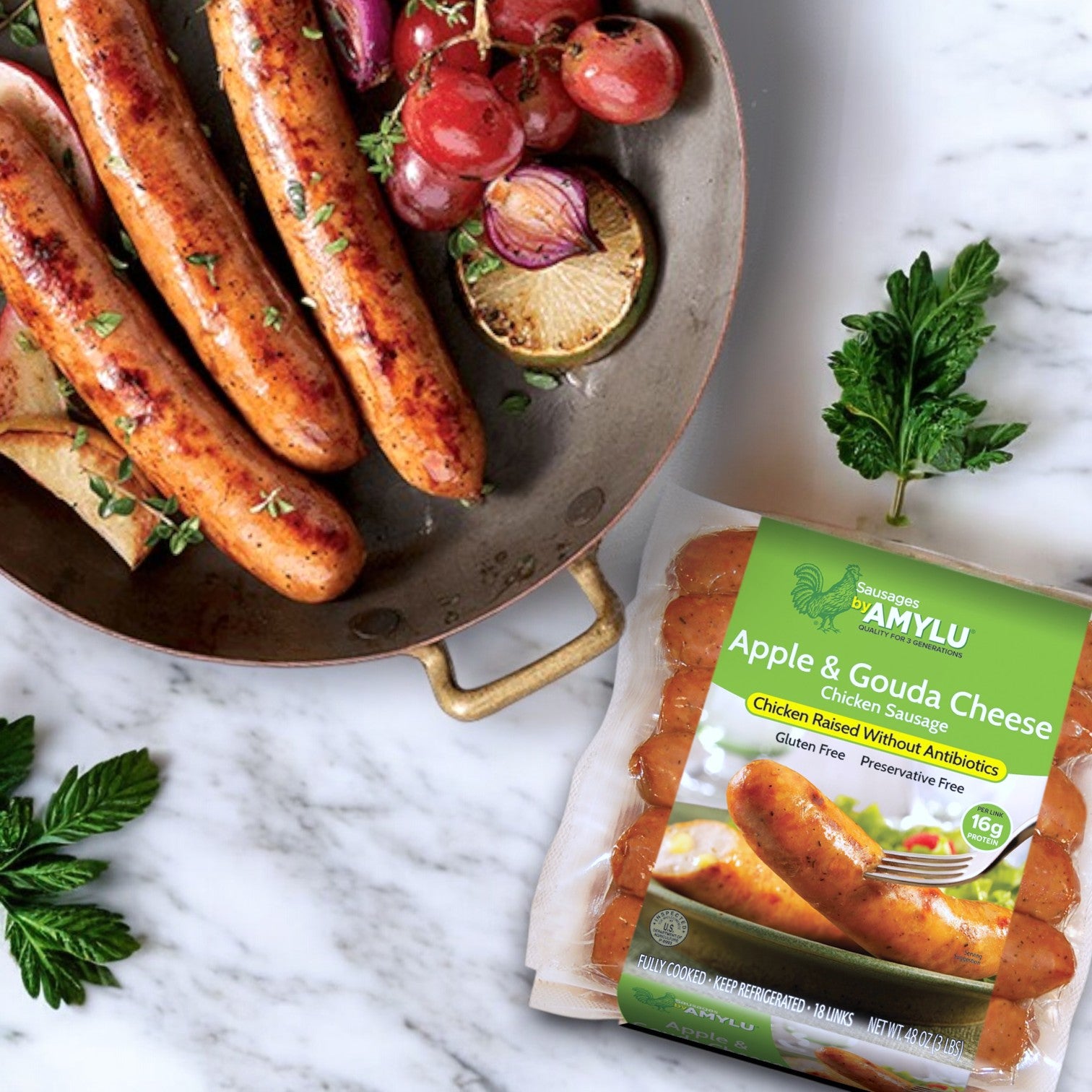 A pan displays cooked sausages and roasted tomatoes, highlighting the gourmet taste of Amylu Apple & Gouda Cheese Chicken Sausage. Perfect for those looking for a bulk pack option with 9 lbs (54 ct) that doesn't skimp on flavor.