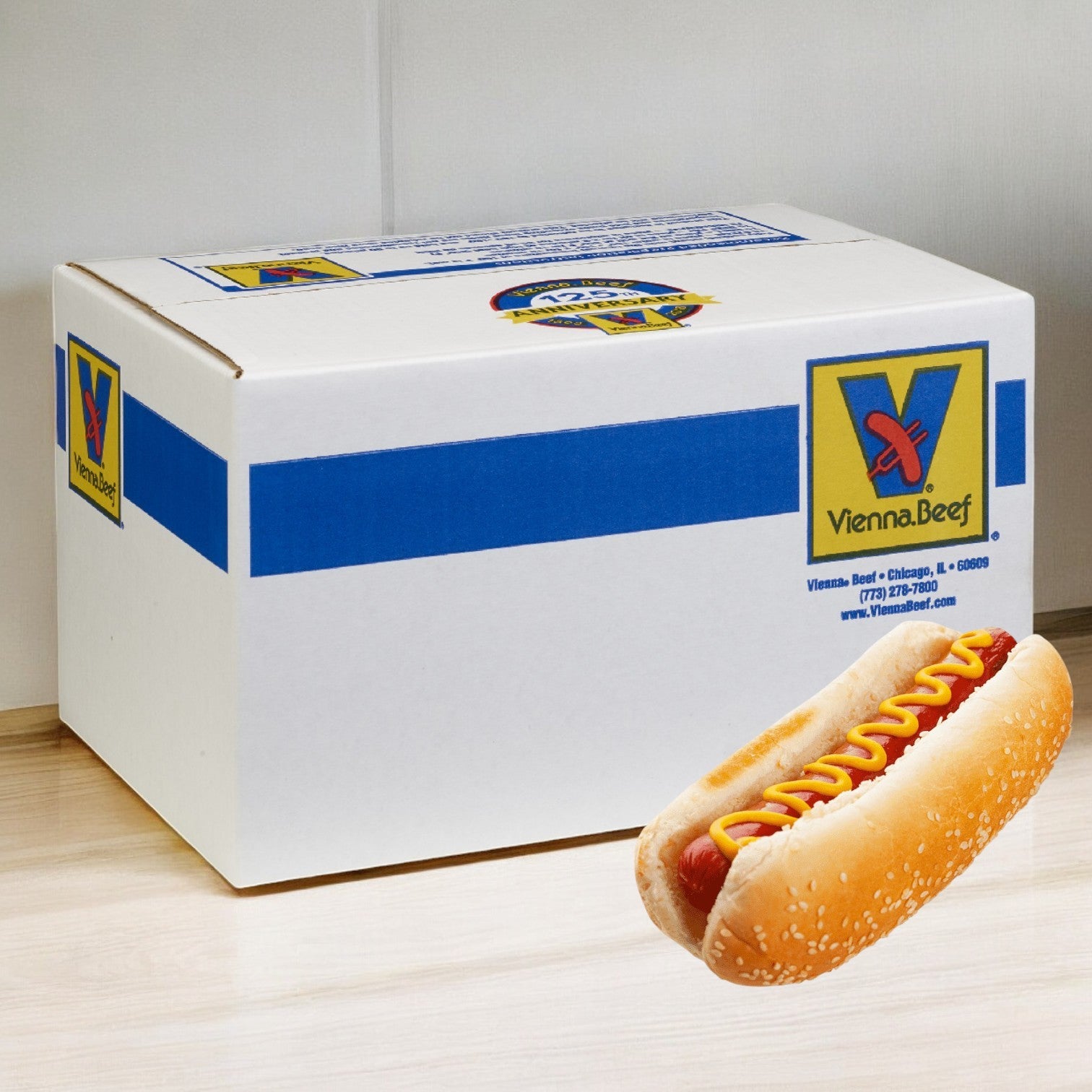 A Vienna Frank All-Beef hot dog from Vienna Beef, topped with mustard, is displayed in front of a branded box on a light wood surface.