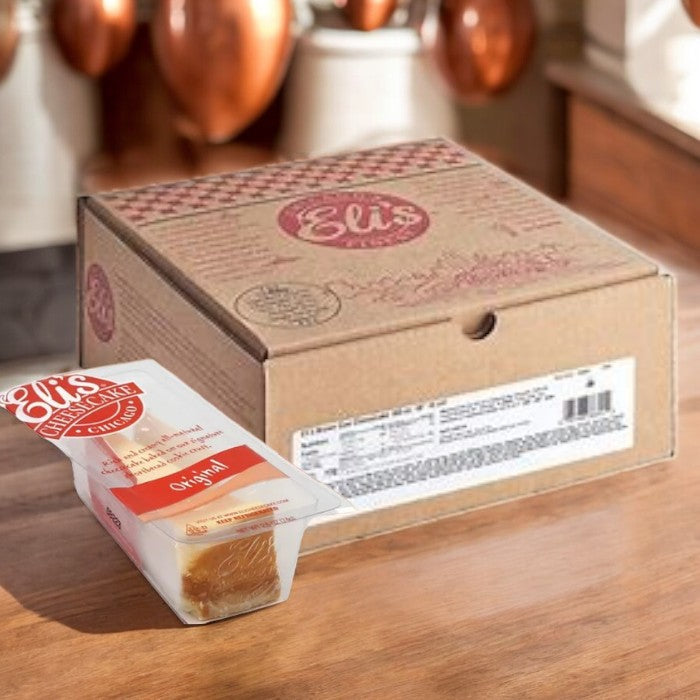 A pack of Eli's Cheesecake Original Plain Single Serve, 3 oz., from a case of 24, sits invitingly on a wooden surface, offering a perfect taste of indulgence.
