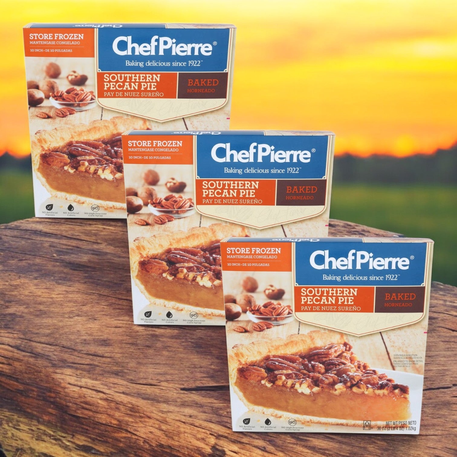 Boxes of Chef Pierre Pre-Baked Southern Pecan Pie, 36 oz. - 3 Count, are displayed outdoors against a sunset backdrop.