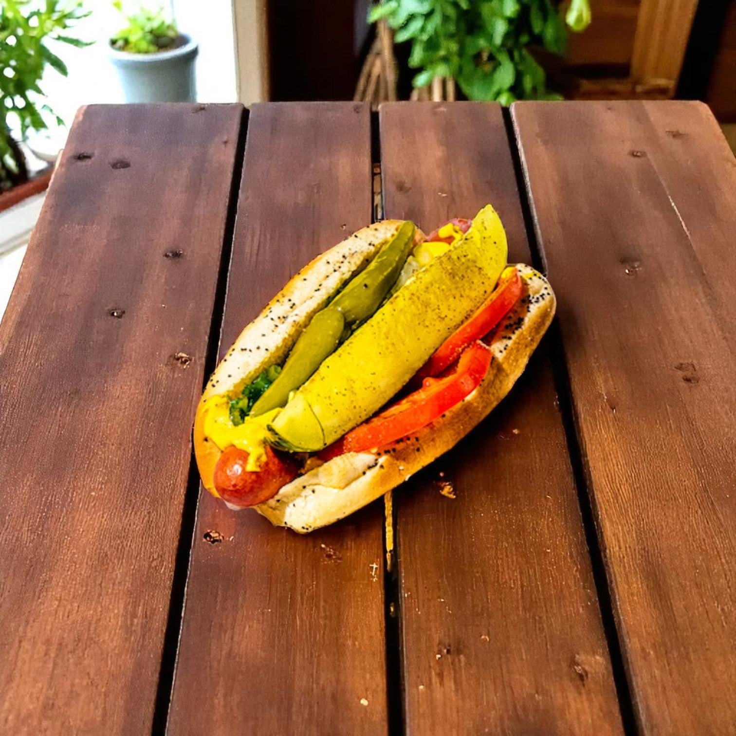 A Chicago-style hot dog featuring Vienna Beef Natural Casing Beef Franks, topped with tomato slices, pickles, peppers, and mustard on a poppy seed bun, served on a wooden table.