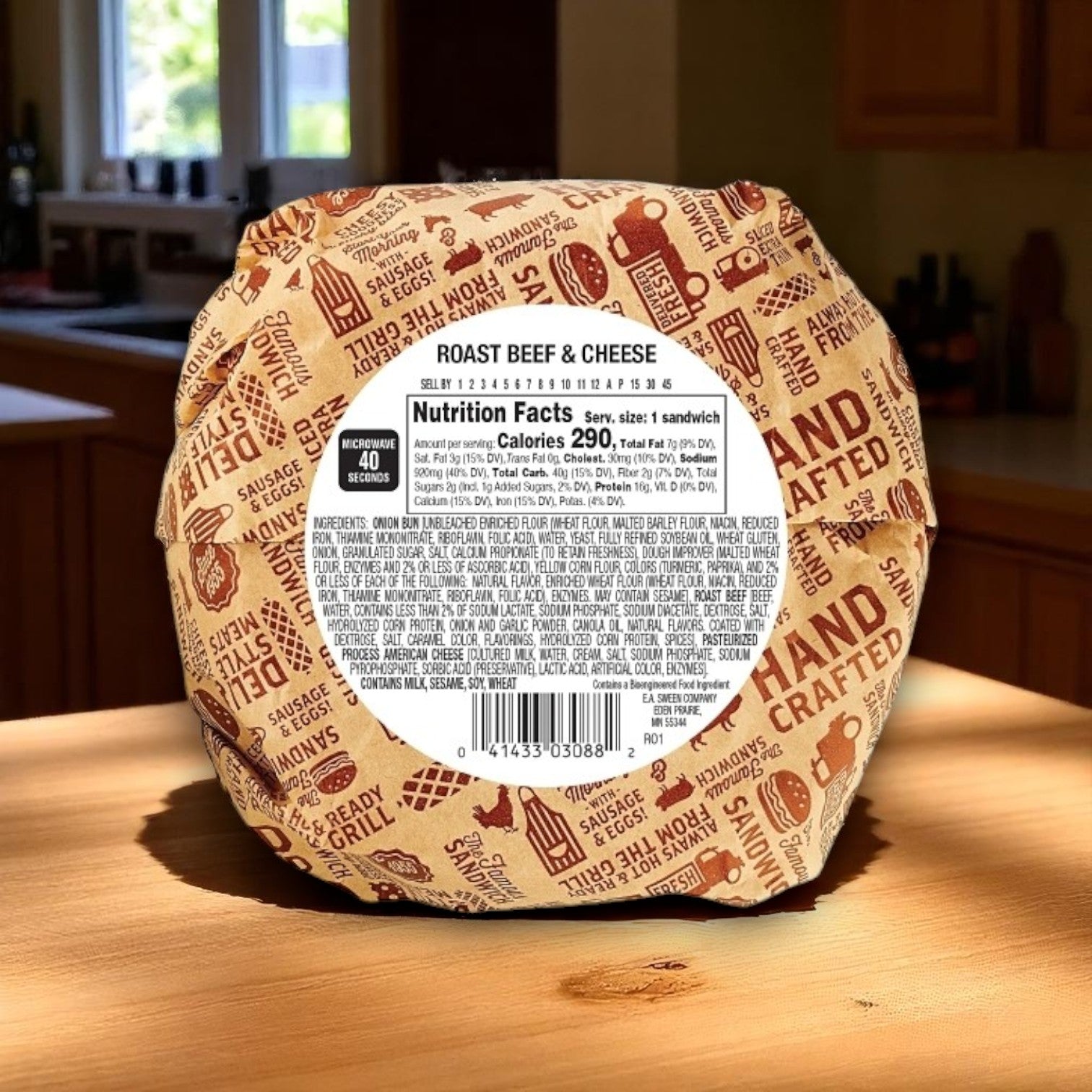 An E.A. Sween Deli Express Roast Beef & Cheese Sandwich (4.3 oz) from a 10-count case rests on a wooden counter, its nutrition facts and ingredients label visible on the individually wrapped packaging.