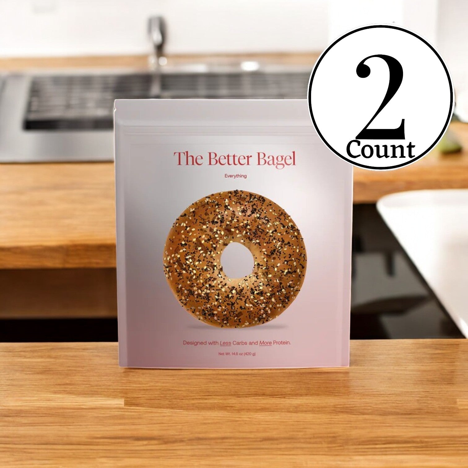 A package from the BetterBrand Variety Pack, featuring "The Everything Bags," sits on a kitchen counter, highlighting its innovative take on everything bagels. Offering less carbs and more protein, this nutritious choice provides a delicious alternative to traditional bagels.