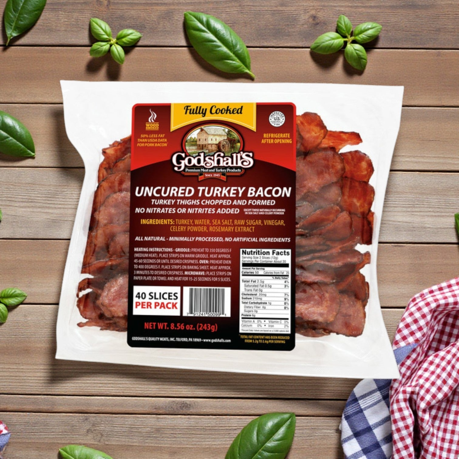 A bundle of Godshall's Uncured Fully-Cooked Turkey – 40 oz (3 Pack Bundle) rests on a wooden table, accented by basil leaves and a checkered cloth.