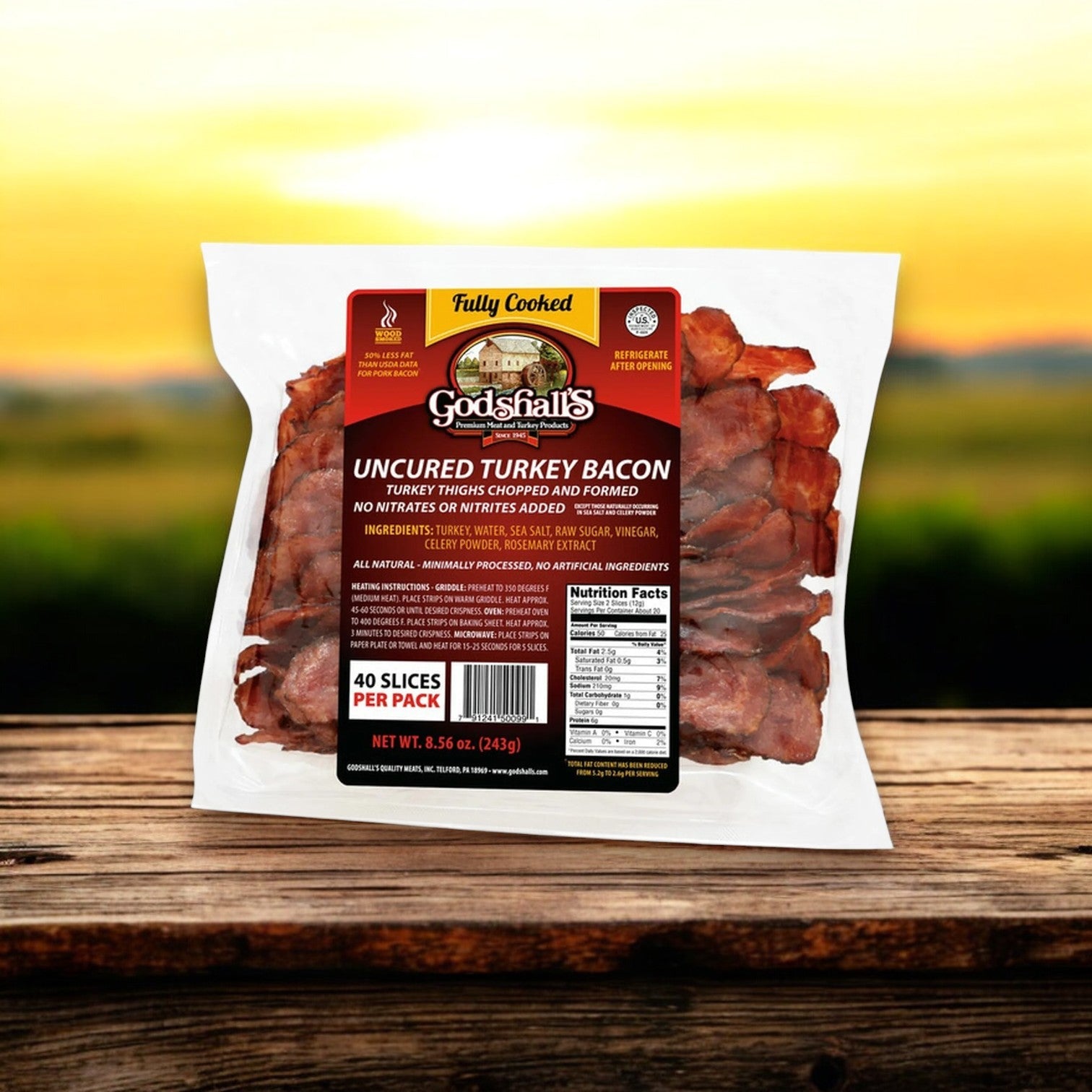 A 40 oz package of Godshall's Uncured Fully-Cooked Turkey Bacon rests on a wooden table with a blurred outdoor background. The label from Godshall's clearly displays product and nutritional details for easy selection.