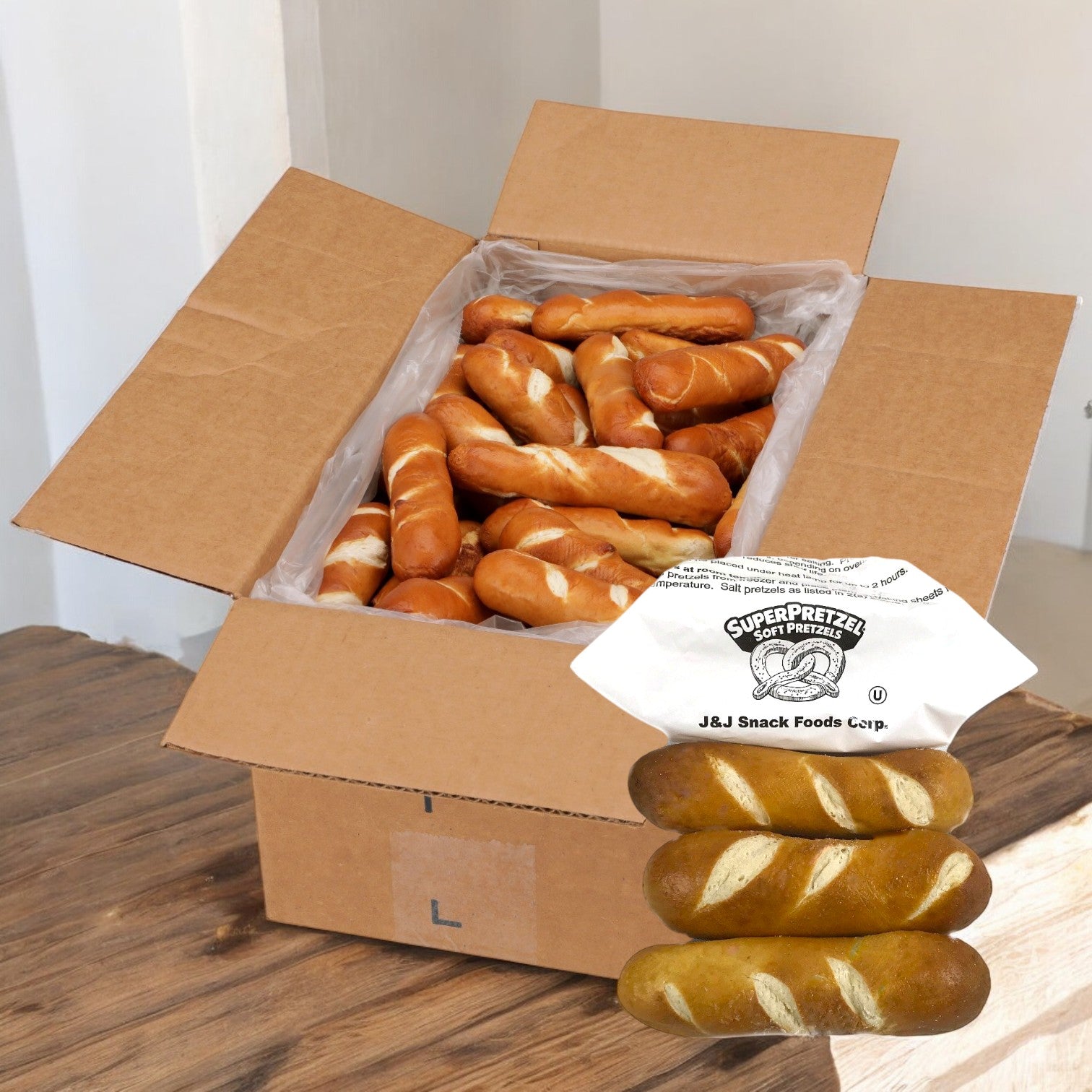 A cardboard box filled with J&j Snacks Pretzel Bavarian Stick Minis, 1.2 oz - 100 count, awaits enticingly in front, ready to satisfy your snack cravings.