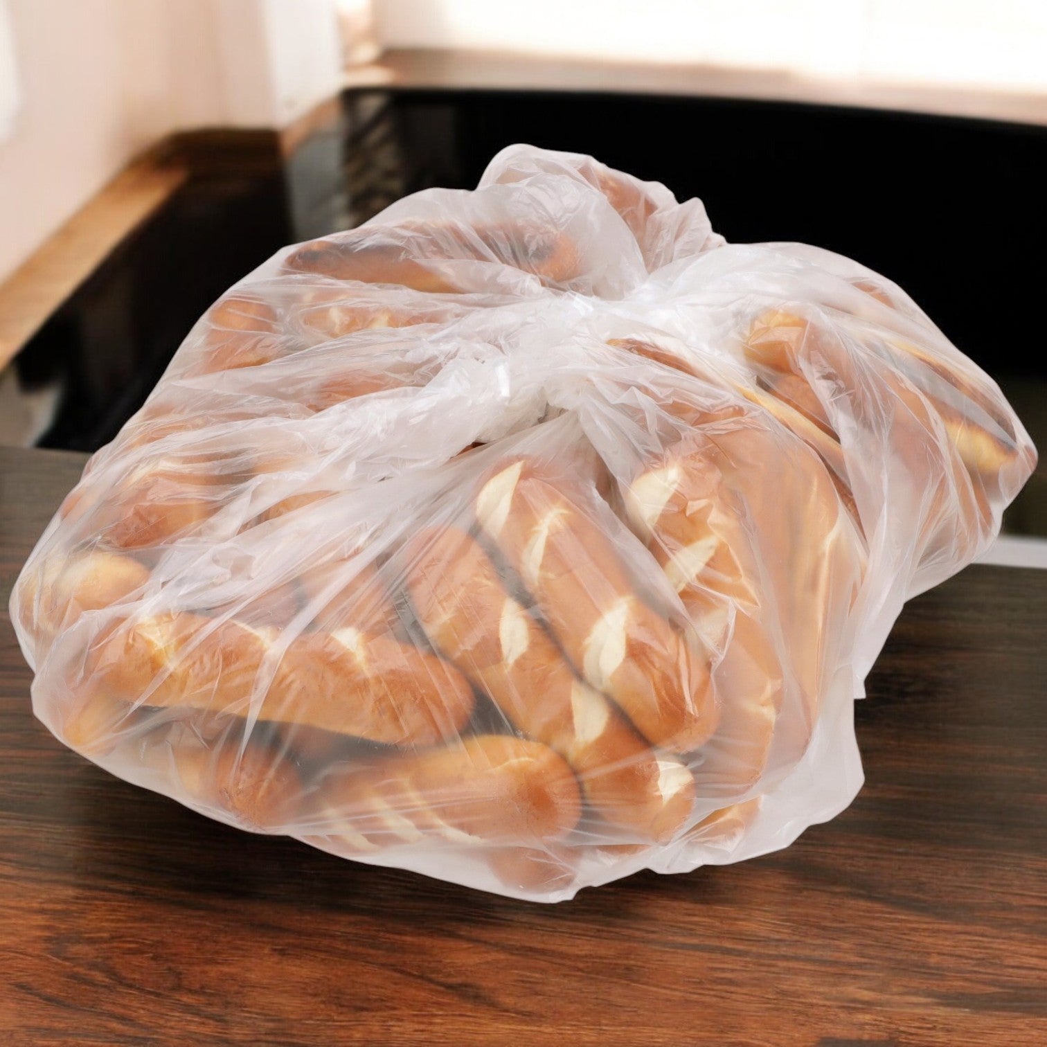A clear plastic bag filled with J&j Snack's Pretzel Bavarian Stick Minis, a great choice for snack cravings, sits on a wooden table.