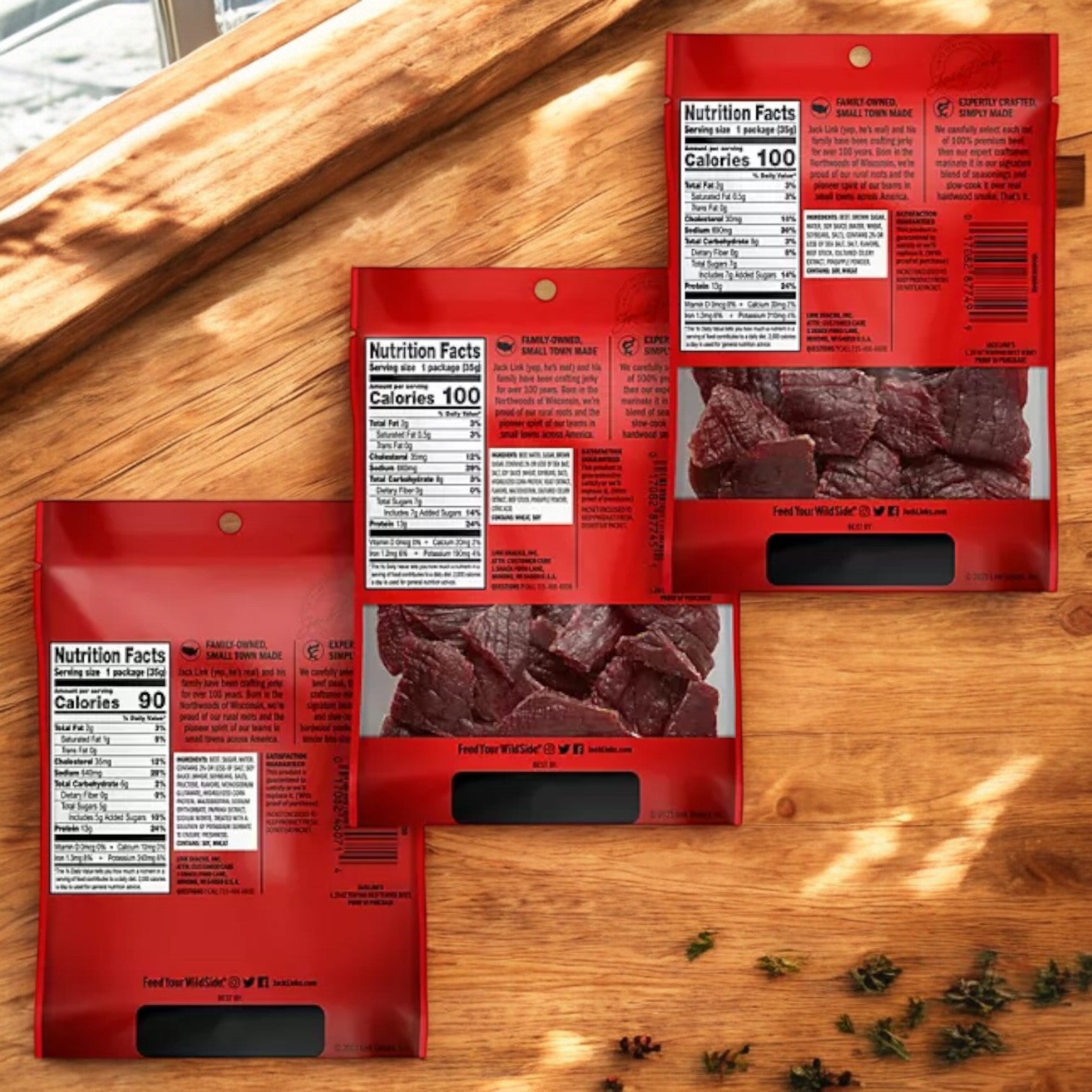 Nine-count Jack Link's Beef Jerky Variety Pack on a wooden surface, featuring clear nutrition facts labels and visible premium beef jerky pieces through transparent windows.