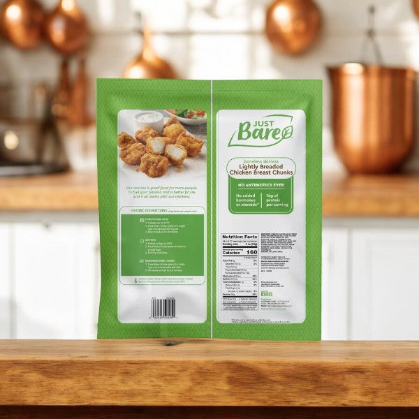 A package of Just Bare Lightly Breaded Chicken Breast Chunks, Boneless Skinless (4 lbs - 1 Pack) is displayed on a kitchen counter, showcasing its premium quality with clearly visible front and back labels detailing ingredients, nutritional facts, and preparation instructions.