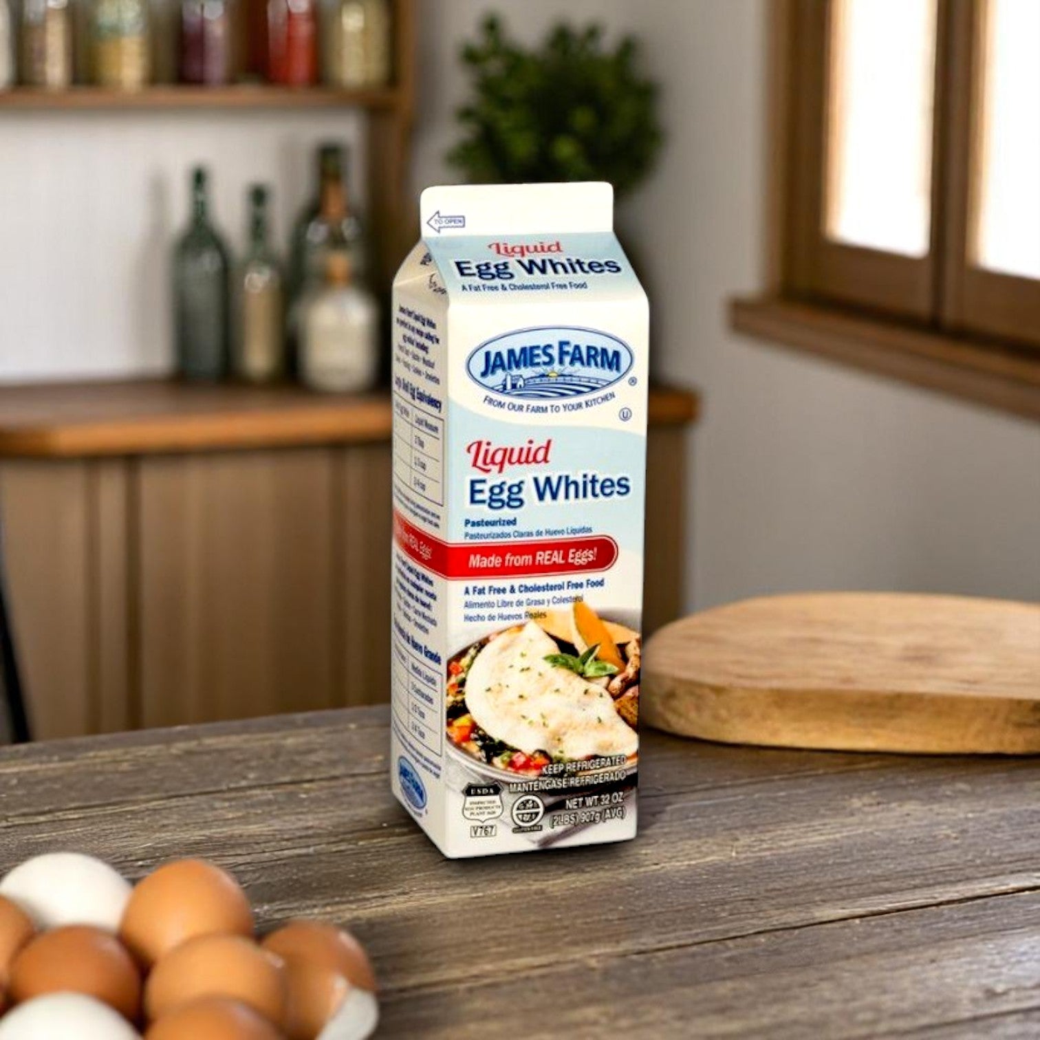A 2 lb carton of Restaurant Depot’s James Farm Egg Whites (case of 15) sits on a wooden kitchen counter beside brown eggs, providing a convenient and high-quality protein source, with a blurred kitchen background.