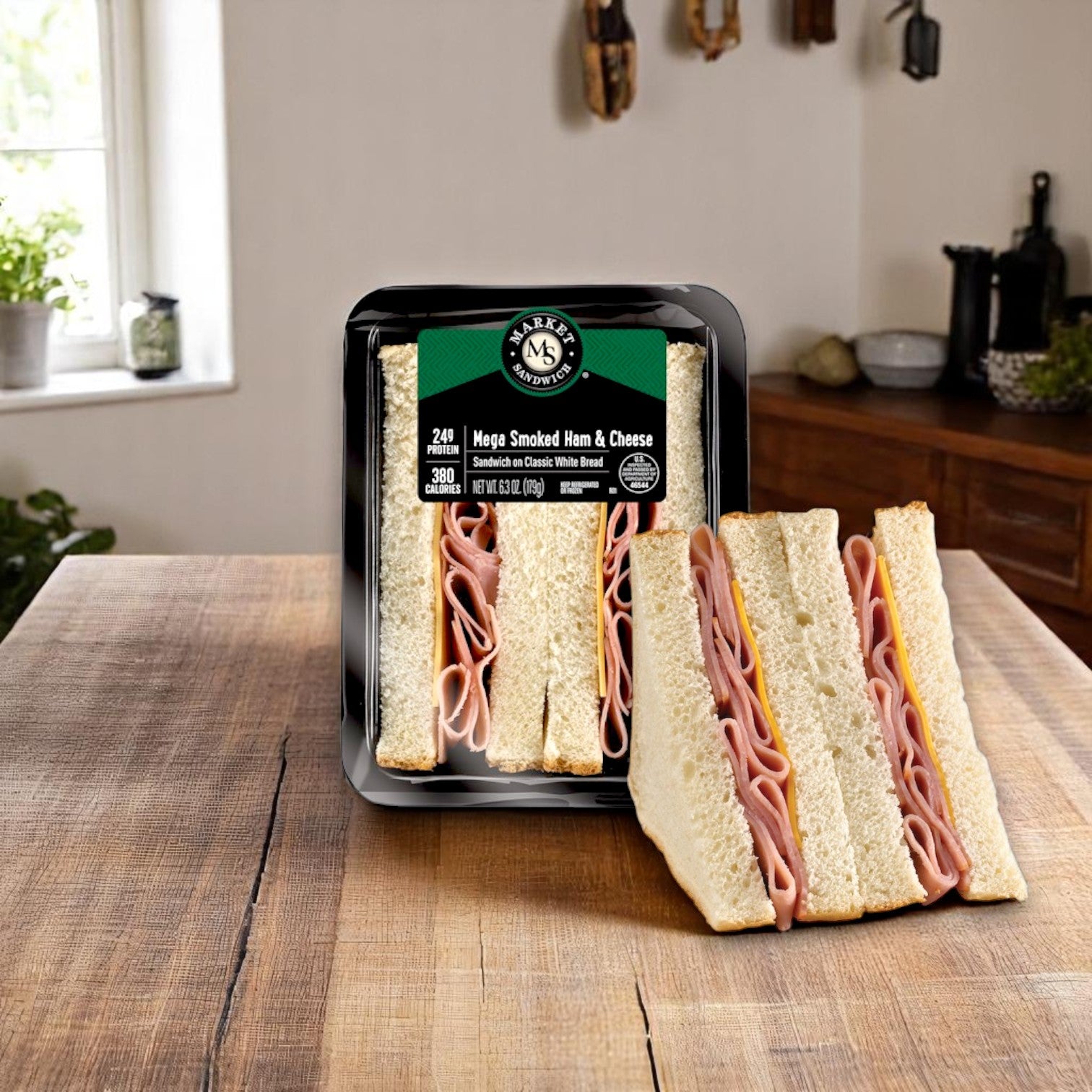 E.A. Sween Market Mega Smoked Ham & Cheese Sandwich Wedge – 6.3 oz, individually wrapped for grab-and-go convenience, is displayed on a wooden table in a cozy kitchen setting.