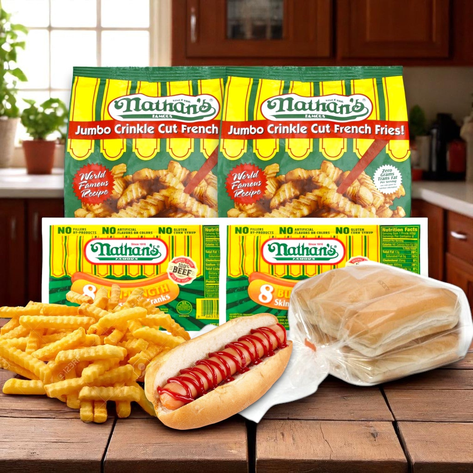 Nathan's Famous Hot Dog & Fries Bundle—16 hot dogs, 16 buns, and 2 bags of fries—appears with packaging on a kitchen counter, set against a backdrop of a window and plants.