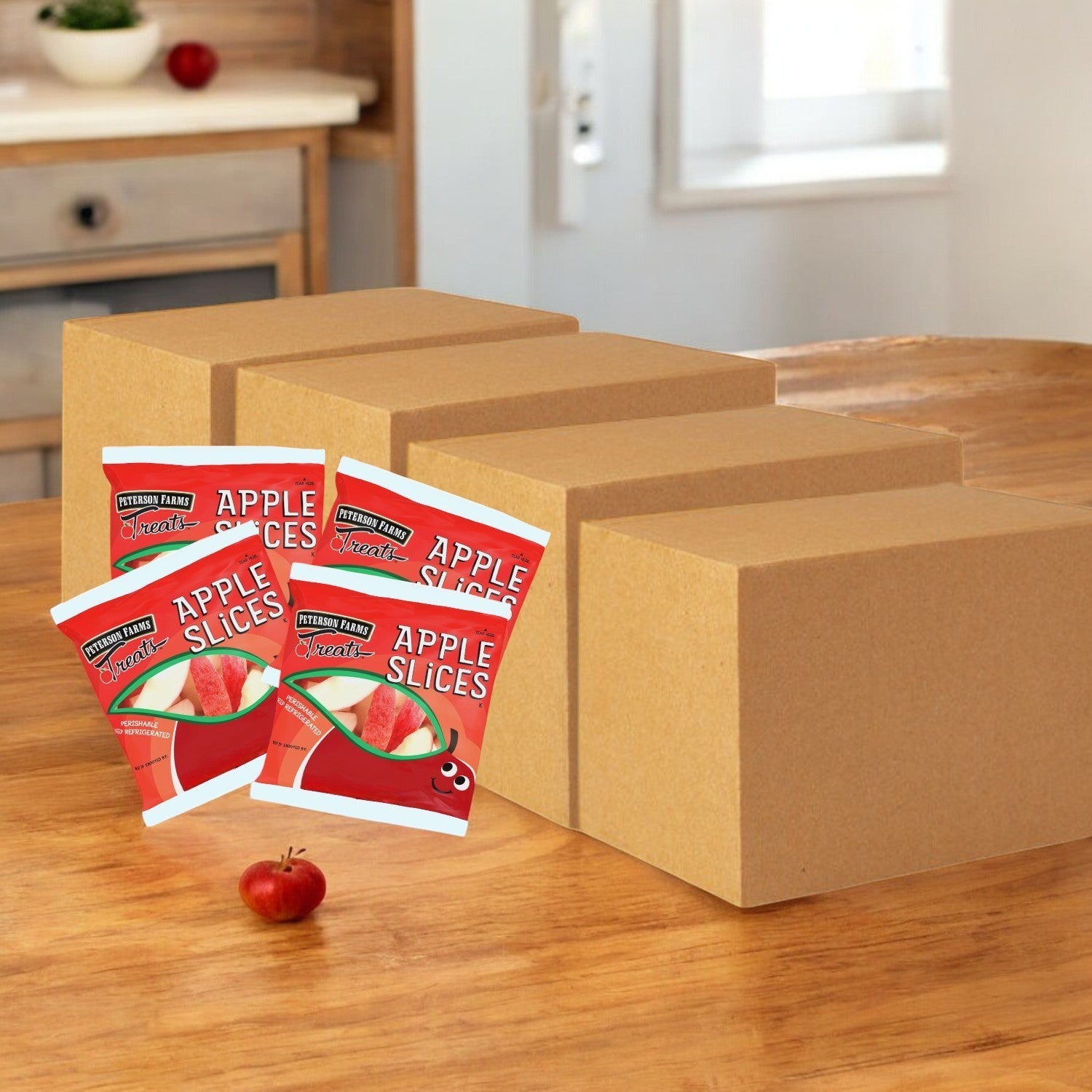 Peterson Farms Fresh Apple Slices packets are displayed on a wooden table with an apple nearby, offering convenient and nutritious snacks perfect for any kitchen setting. Each bulk set contains 400 packs with a shelf life of over 7 days upon delivery.