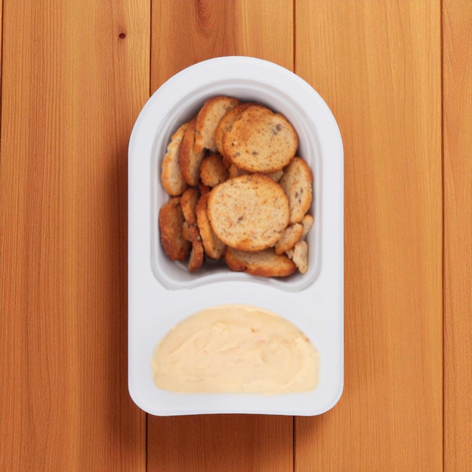 Kraft's Philadelphia Multigrain Bagel Chips & Garden Vegetable Cream Cheese Dip (2.5 oz.) snack pack features crisp chips and creamy dip, served side by side on a wooden surface.