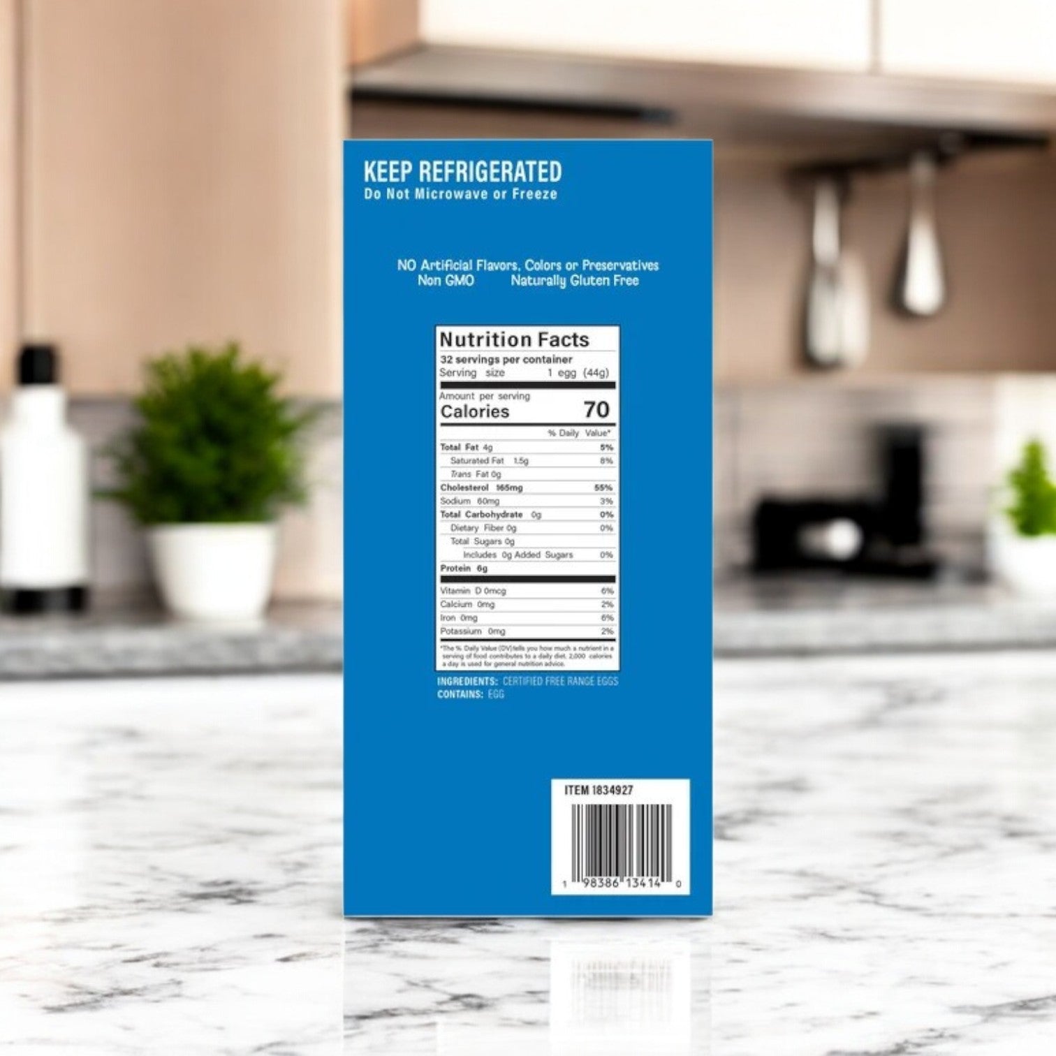 A blue Pure Provisions box of Free Range Hard Boiled Eggs (16 packs) sits on a kitchen counter, showing nutrition facts, storage instructions, and a barcode. Labeled as a Protein-Packed Snack; blurred plants and kitchen items are in the background.