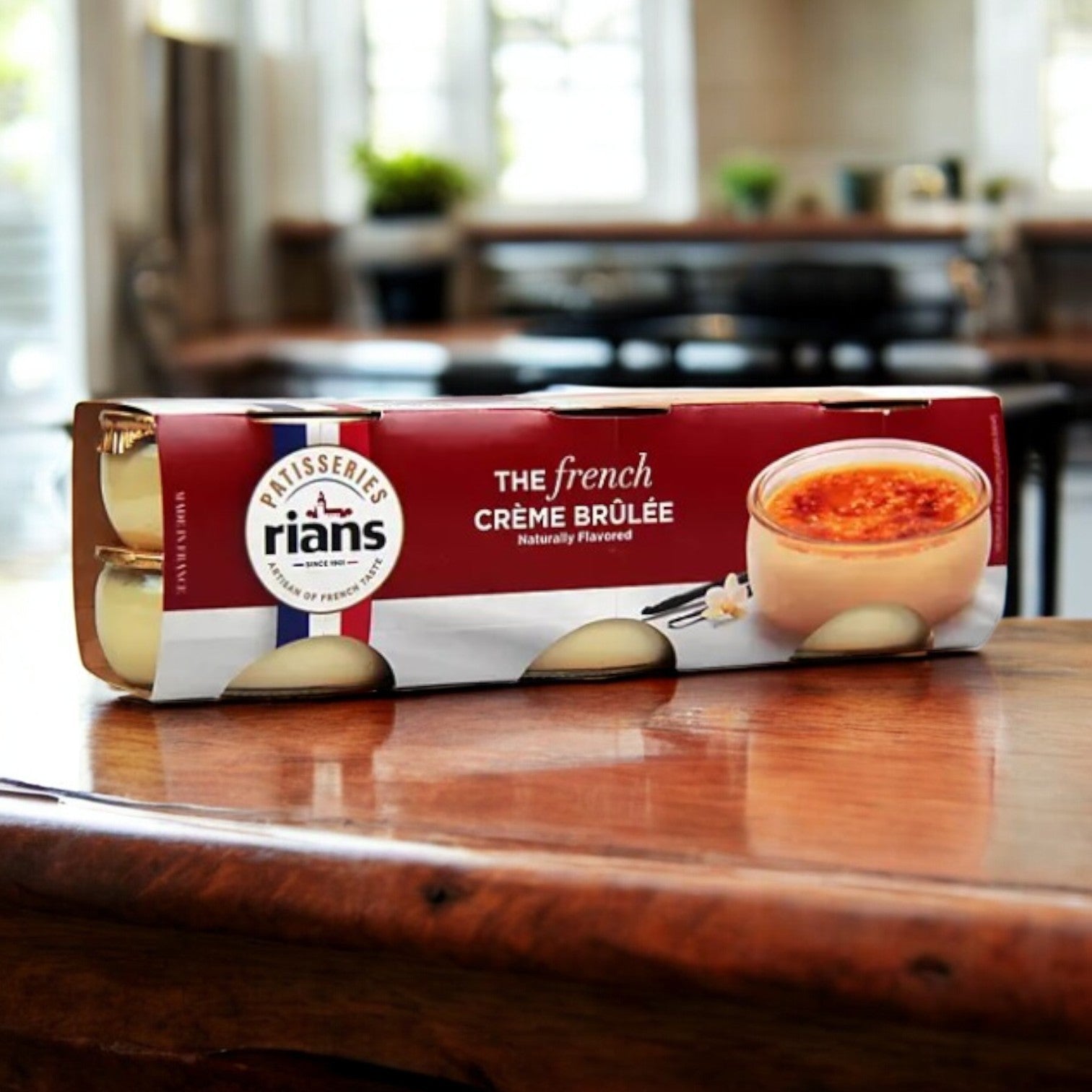 A package of Rian's La Crème Brûlée, a decadent French dessert, sits elegantly on a wooden countertop in a kitchen setting.