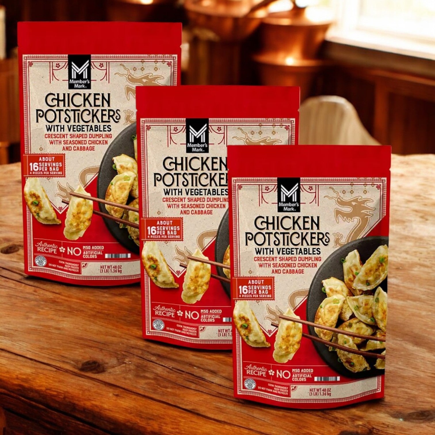 Three cases of Member's Mark Chicken Potstickers with Vegetables, 48 oz each, are displayed on a wooden table with a blurred kitchen background.