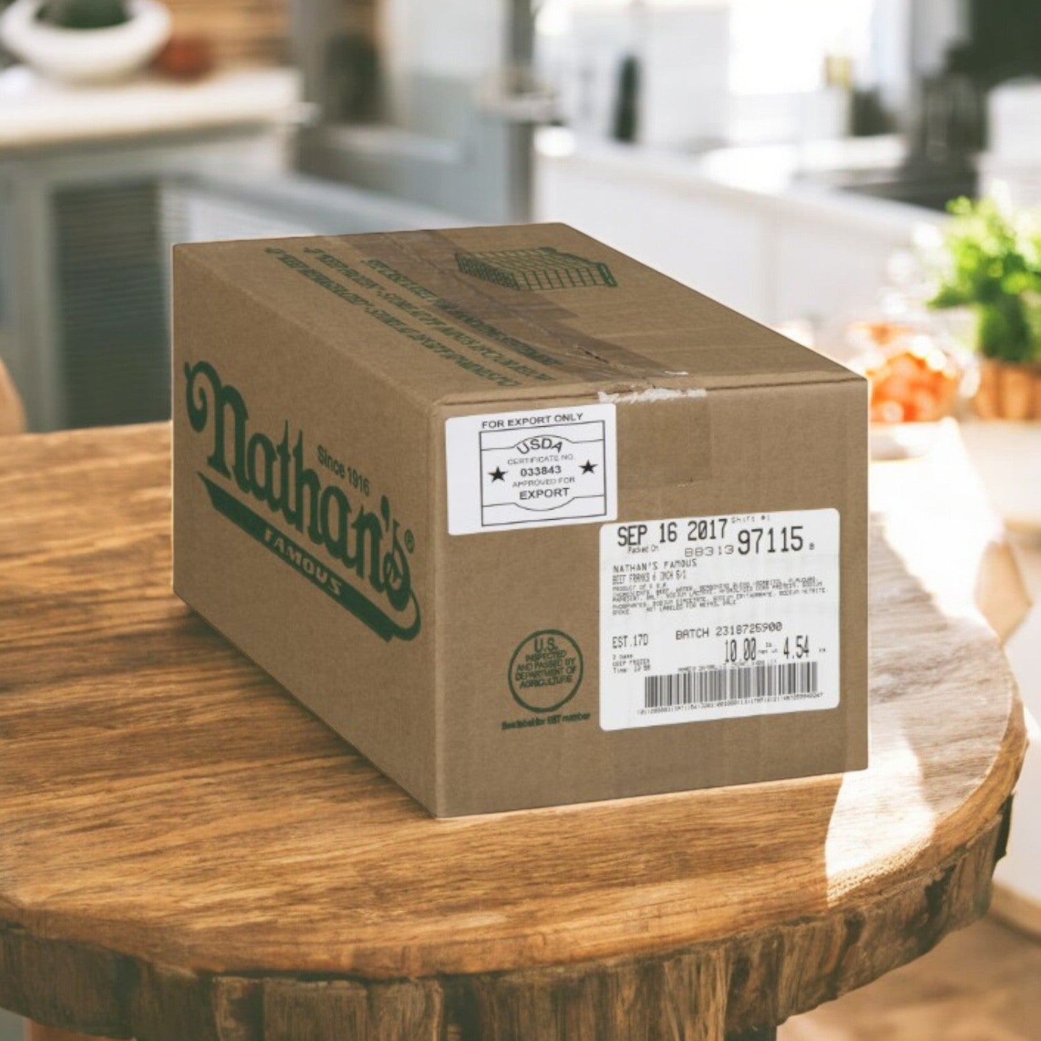A 10 lb box of Nathan’s Famous All-Beef Frankfurters (50 hot dogs, 6-inch) is displayed on a wooden kitchen table, with shipping and export labels visible.