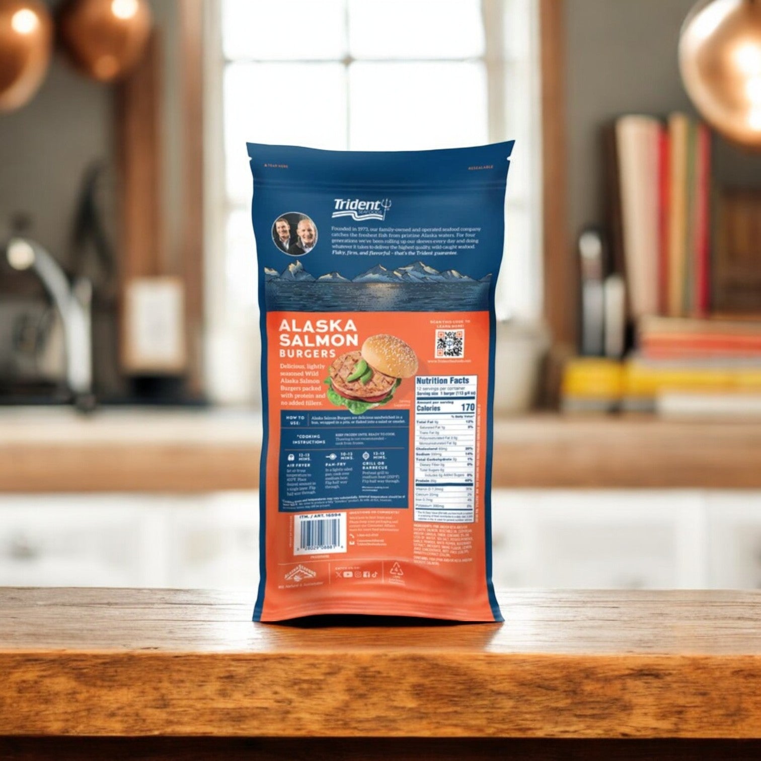 A 48 oz bag of Trident Seafoods Alaskan Salmon Burgers stands on a wooden countertop, featuring wild-caught salmon, nutritional info, and emphasizing the burgers as a rich source of Omega-3 fatty acids.