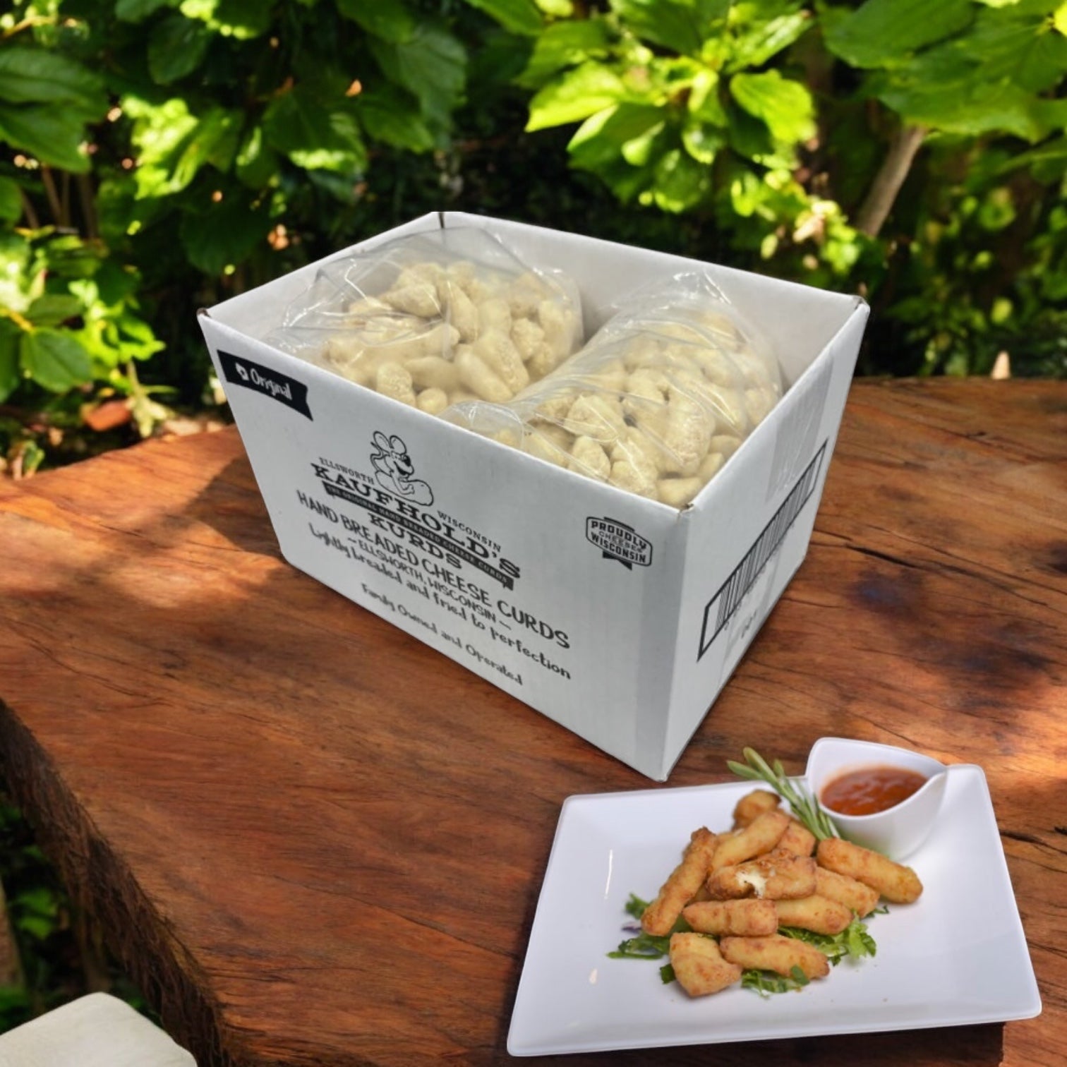 A 10-pound pack of Easy Lunches Appetizer Cheese Curd Breaded sits on a wooden table outdoors next to a plate of these tasty bites and dipping sauce.