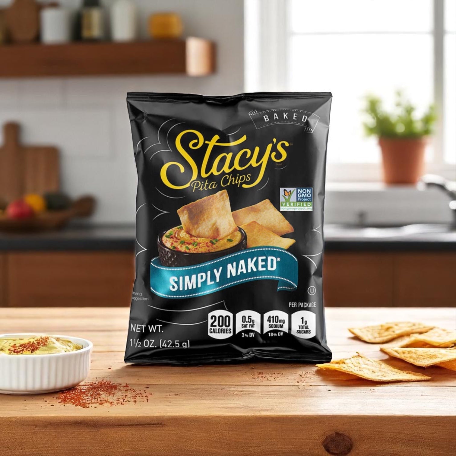 A bag of Easy Lunches Stacy’s Pita Chips Large Single Serving Simply Naked (24 case) sits on a kitchen counter with chips and dip nearby, making it the perfect snack.