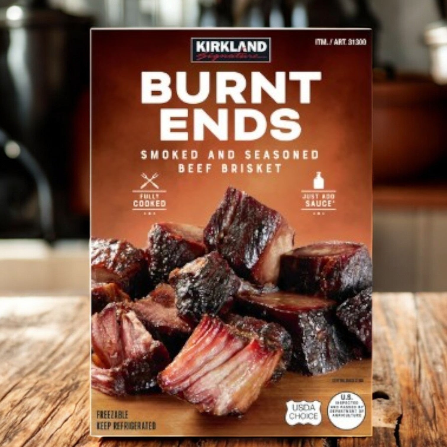 A box of Kirkland Signature Brisket Burnt Ends-1.67 lbs (1 Case) by Kirkland Signature sits on a wooden surface, showcasing this smoked beef brisket favorite from Costco against a kitchen backdrop.