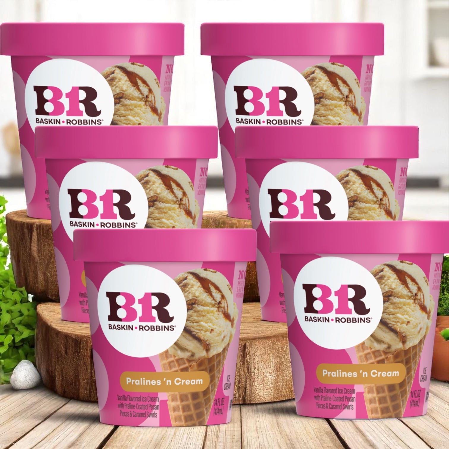 Six 14 oz containers of Easy Lunches Baskin Robbins Pralines 'N Cream ice cream are displayed on a wooden surface, with a blurred kitchen in the background.