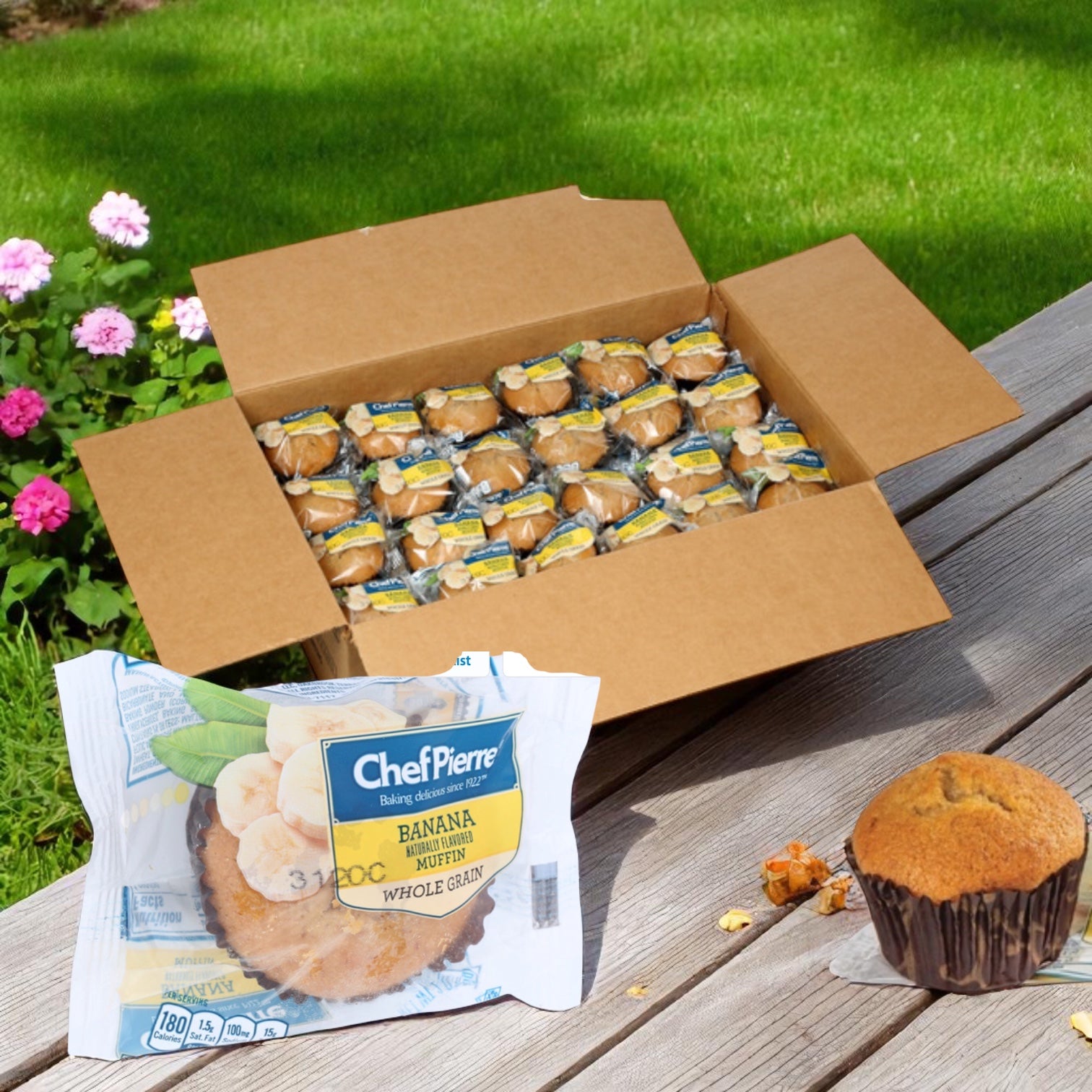 A box of Chef Pierre Muffin Banana Whole Grain Individually Wrapped-48 Count sits on a wooden surface, with one unwrapped and one wrapped muffin displayed in front.