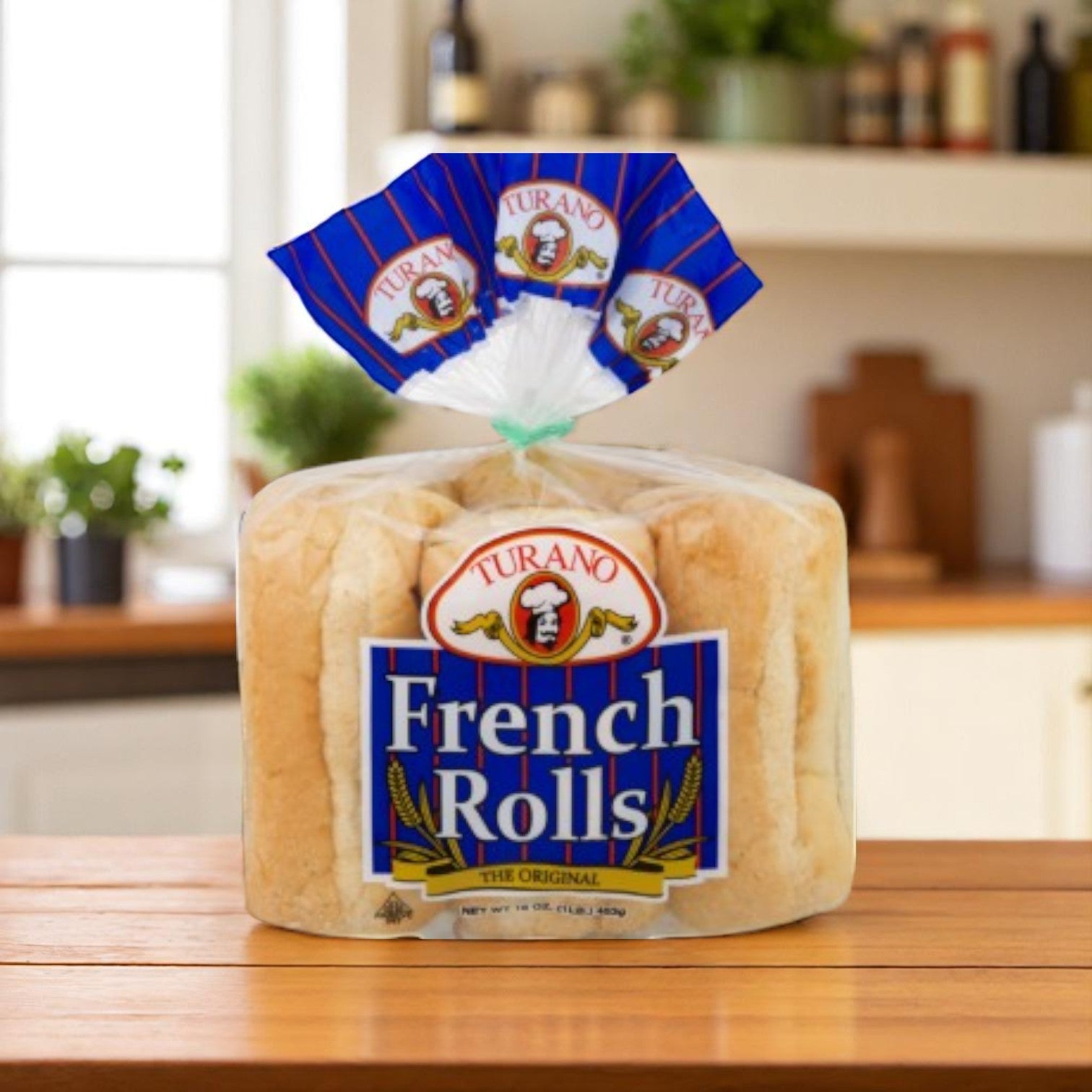 A package of Turano Baking Company French Rolls, 6 count (2.7 oz), is displayed on a wooden countertop in a cozy kitchen setting.