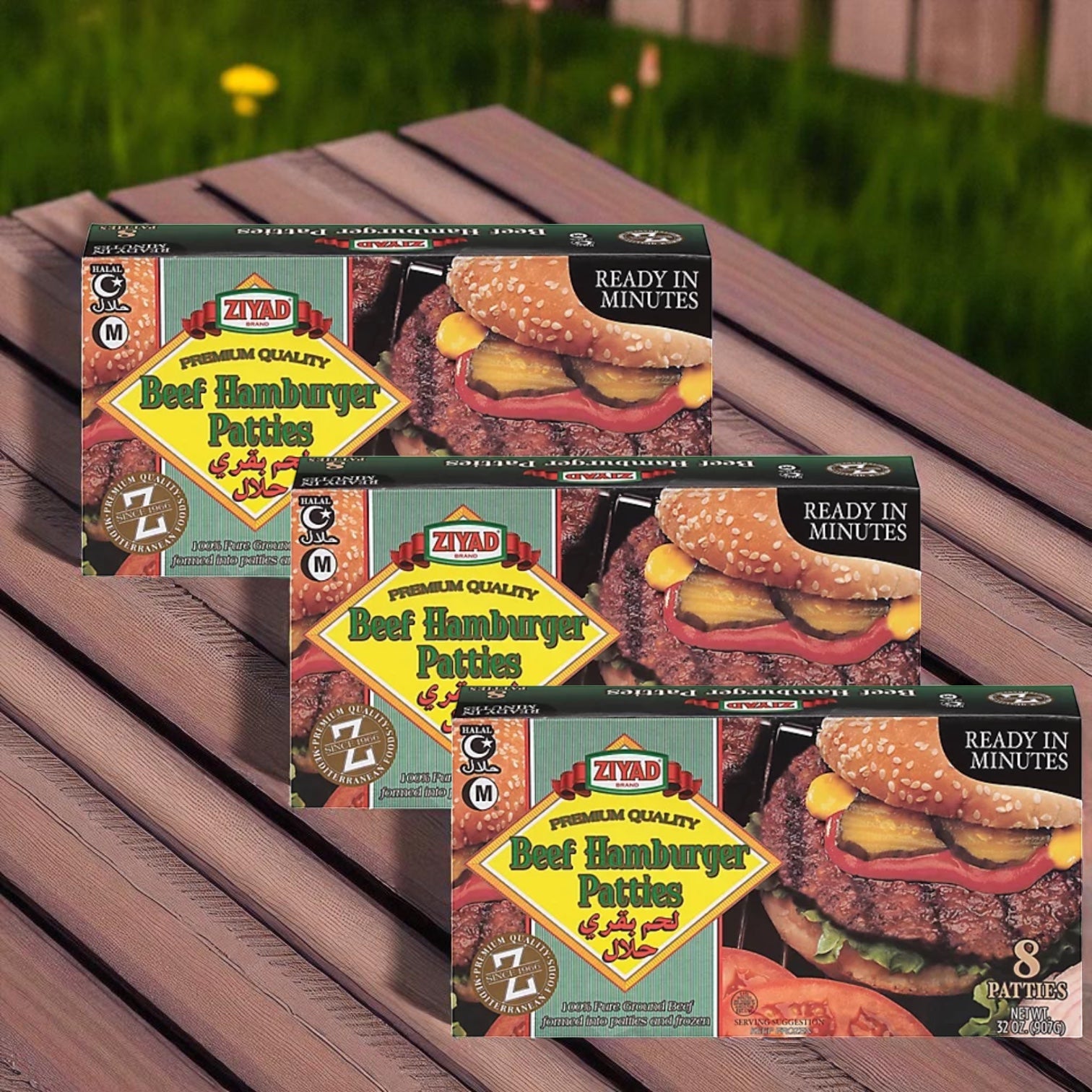 Three boxes of Ziyad Halal Beef Hamburger Patties (32 oz, 3 count) are shown on a wooden surface with grass and a fence in the background.