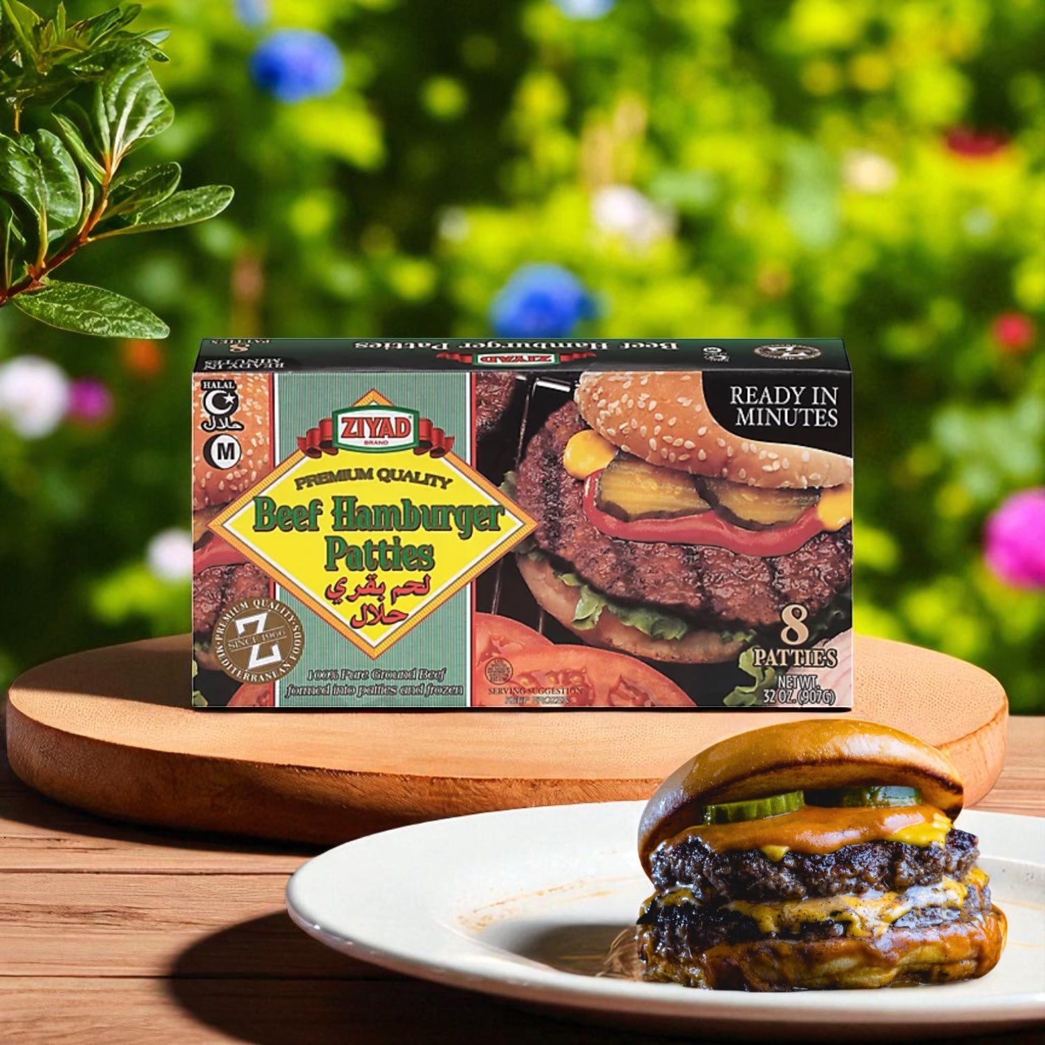 A box of Ziyad Halal Beef Hamburger Patties - 32 OZ is displayed on a wooden platter beside a cooked cheeseburger with pickles and onions, set against a blurred garden background.