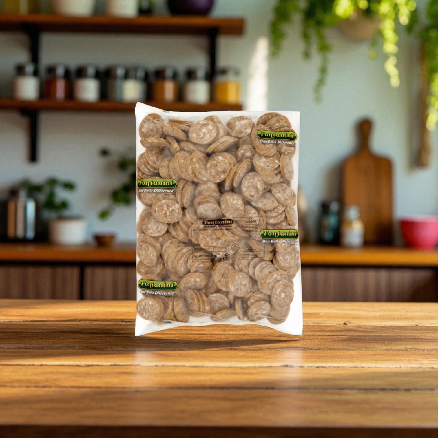 A sealed plastic bag of Sysco Fontanini Italian Honey Cooked Hot Sliced Sausage (5 lb, 3 count) rests on a wooden table in a kitchen setting.
