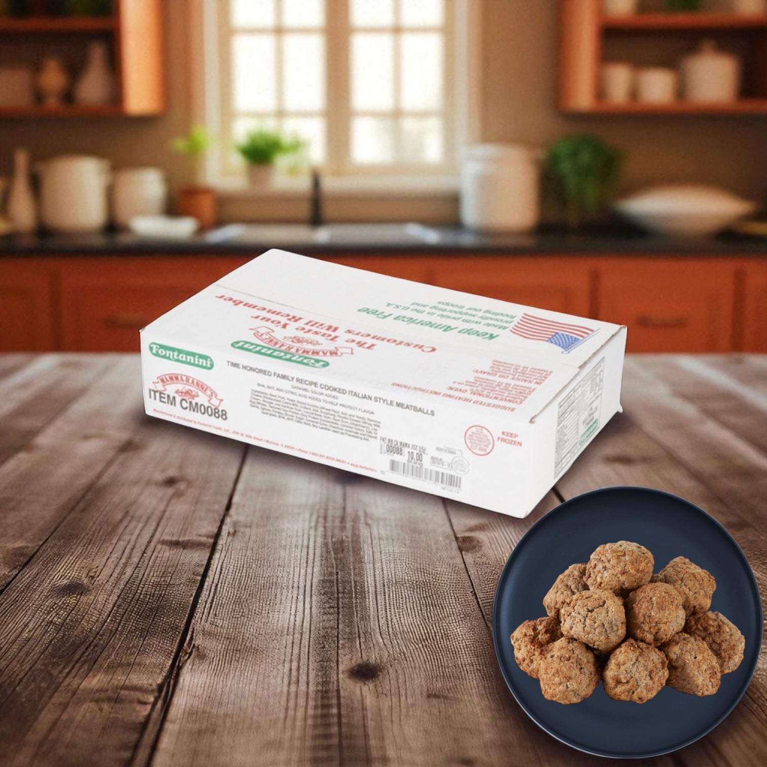 A box of Sysco Fontanini Italian Beef Pork Meatball Fully Cooked 2 Ounce (5 lb, 2 count) sits on a wooden table beside a plate of meatballs, with a kitchen in the background.