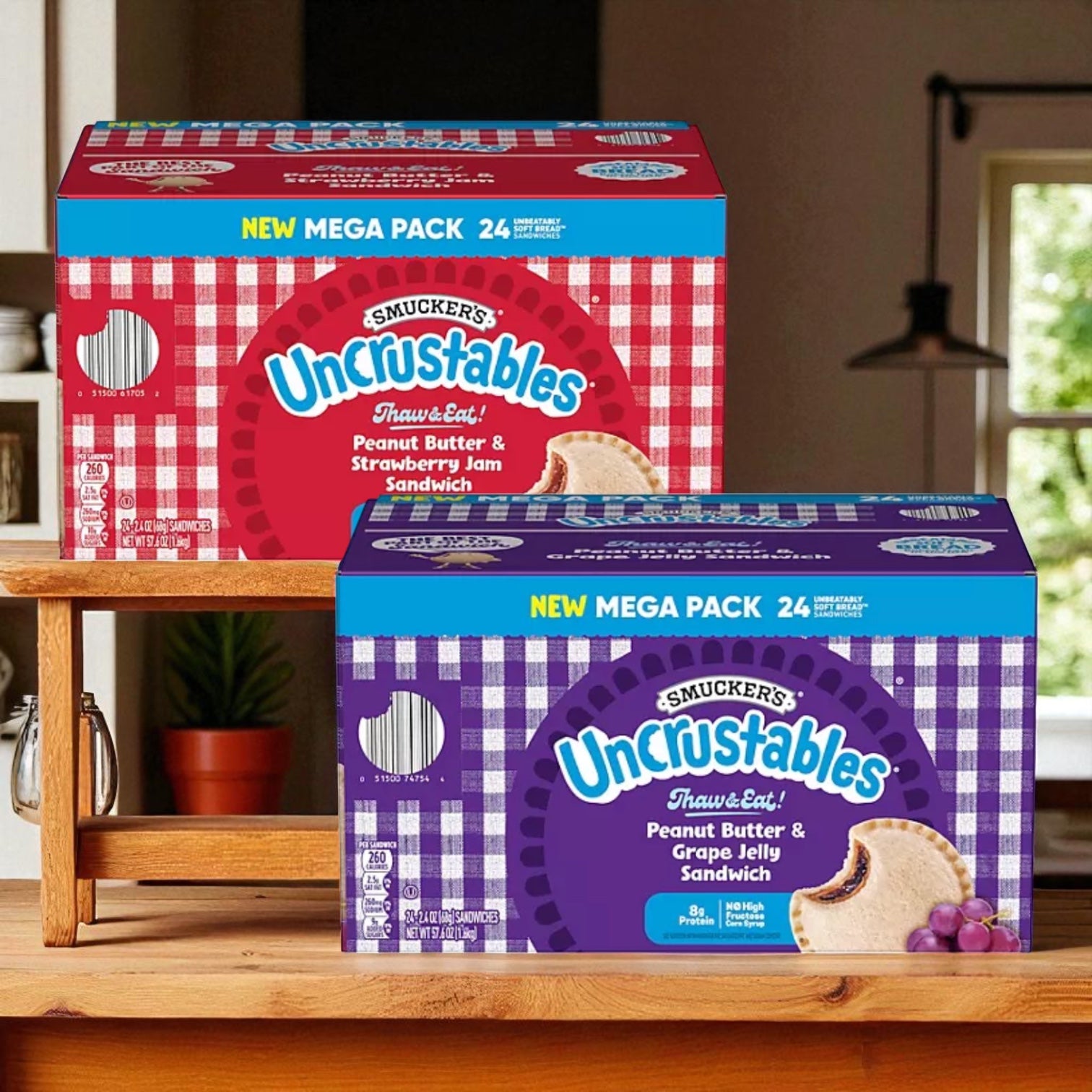 Two boxes of Uncrustable Smuckers Bundle, featuring 24-count Peanut Butter & Strawberry Jam and Peanut Butter & Grape Jelly Sandwiches, sit on a kitchen shelf—ideal for a quick snack.