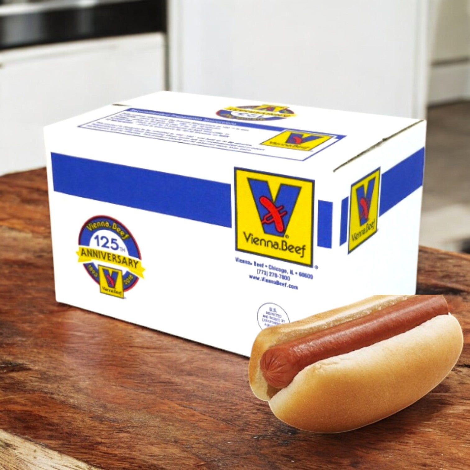 A box labeled "Vienna Beef All Natural Uncured Skinless Beef Franks 6” 8:1 - 80 Total" rests on a wooden surface with a plain hot dog in a bun in front, showcasing Vienna Beef's commitment to high-quality, all natural franks.