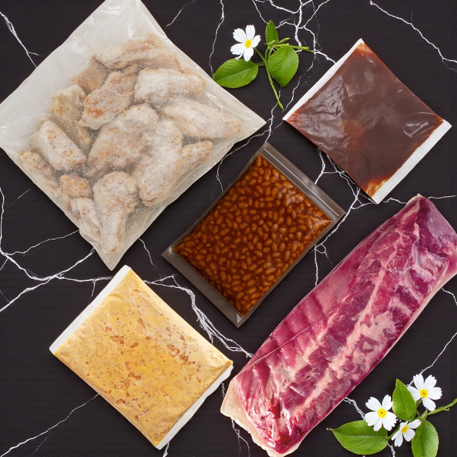 A flat lay of TJ Ribs - Full Single Dinner by TJ Ribs on a black marble surface—perfect for a BBQ meal, surrounded by white flowers and green leaves.